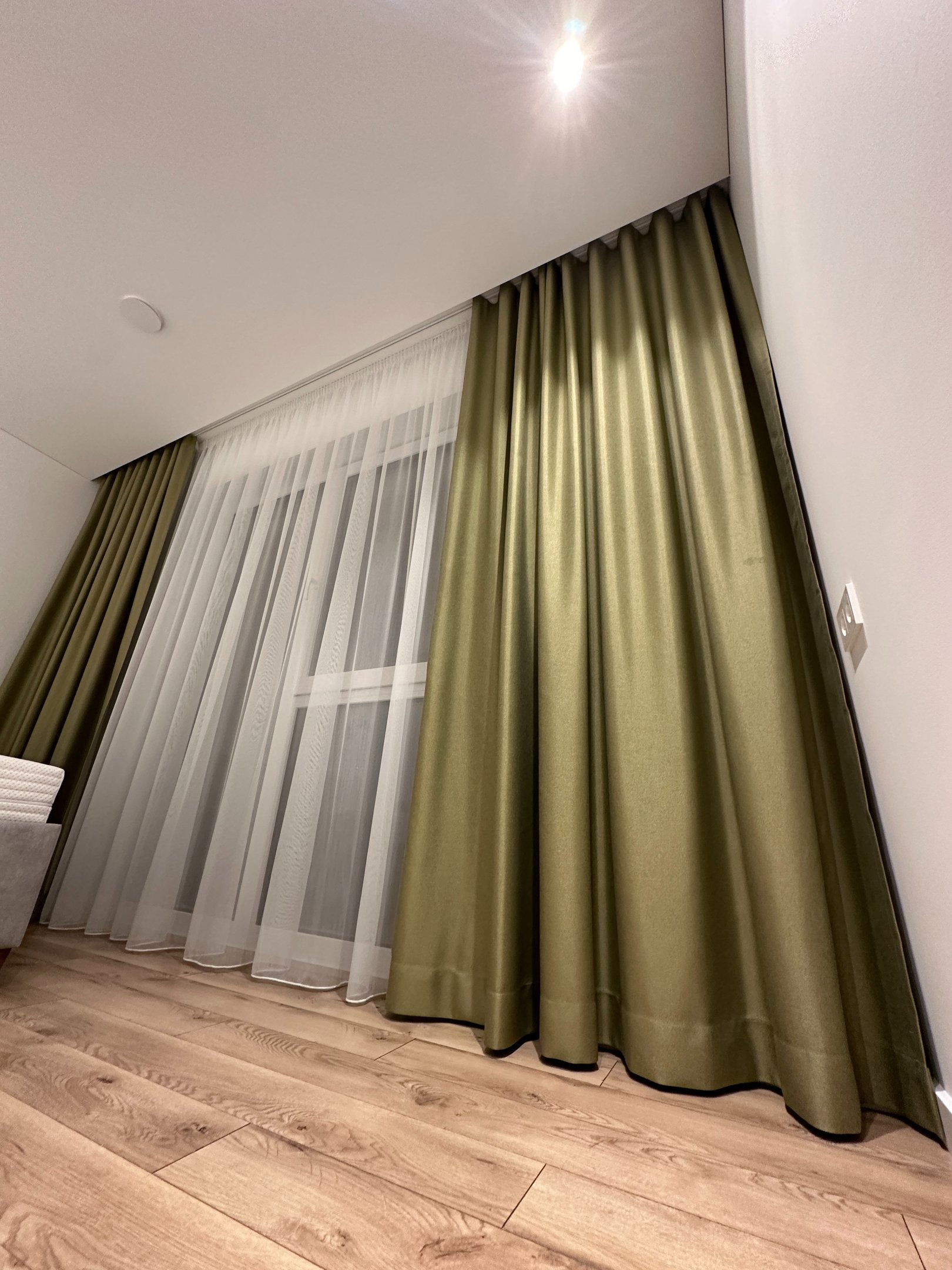 žalios spalvos akcentinės užuolaidos miegamajame