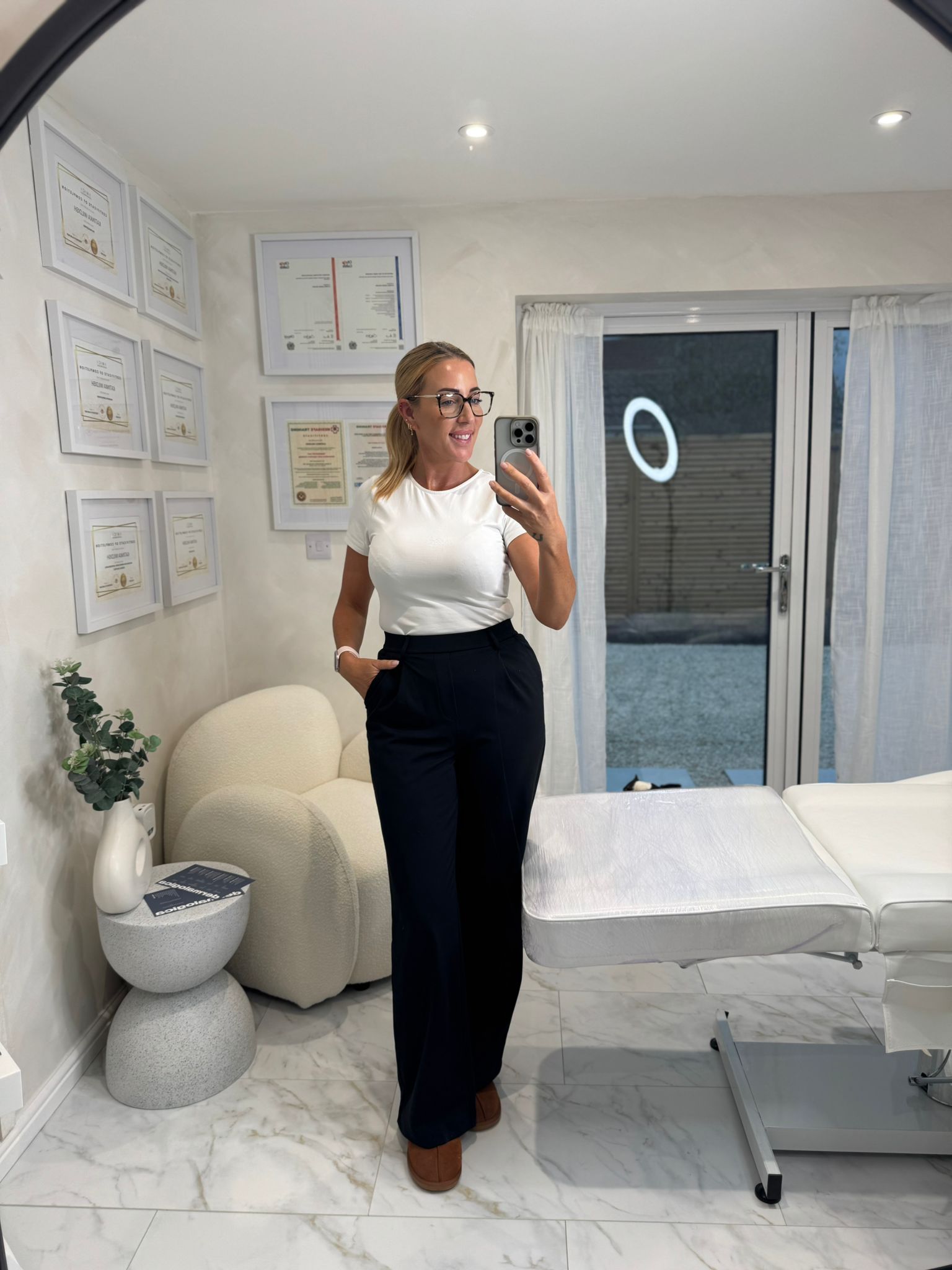 owner of beauty clinic standing with welcoming smile and her qualification certificates