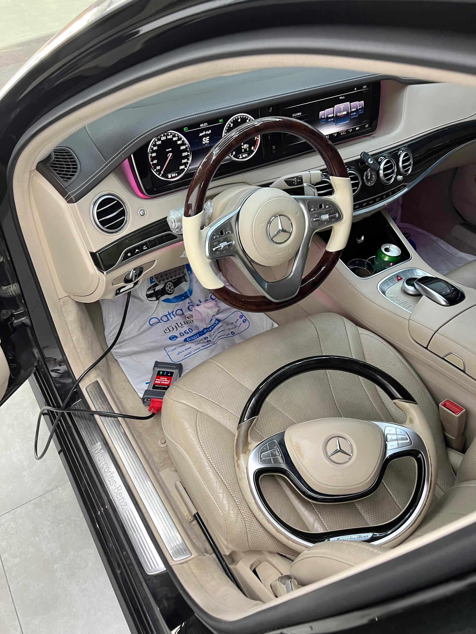 Luxury Mercedes-Benz interior featuring a wood-trimmed steering wheel and digital dashboard display.