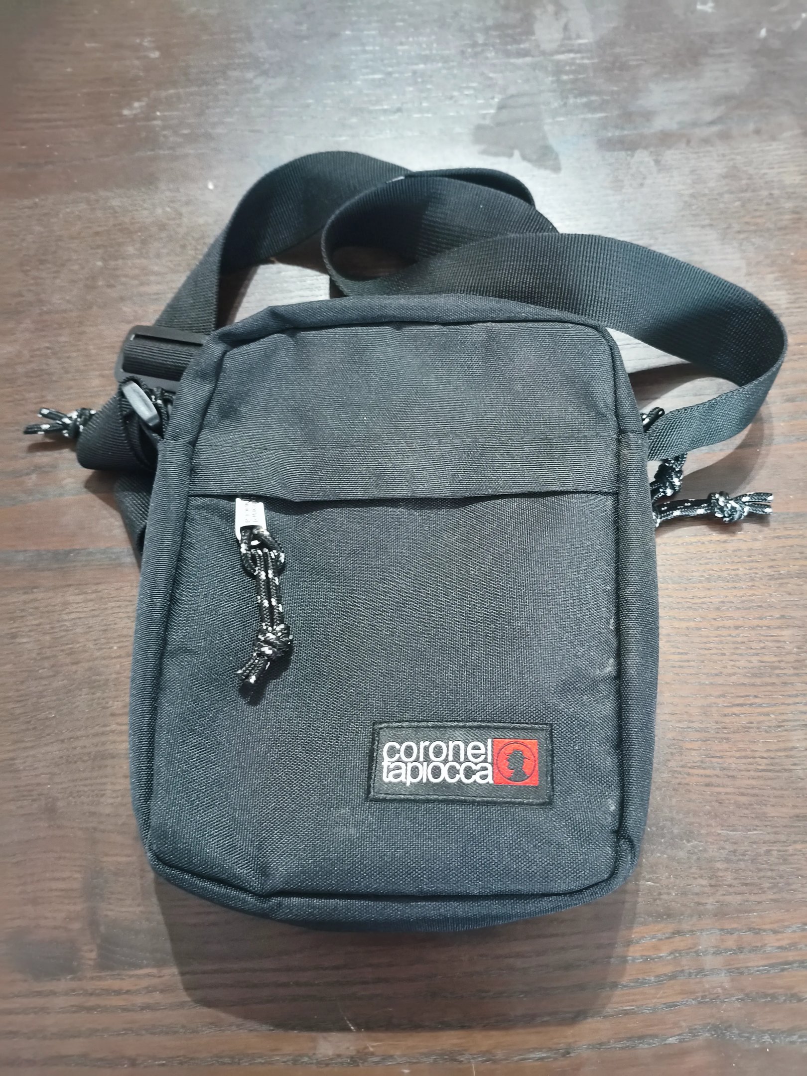 Análise do bolso frontal e tecido resistente de mala tiracolo preta da marca Coronel Tapiocca.