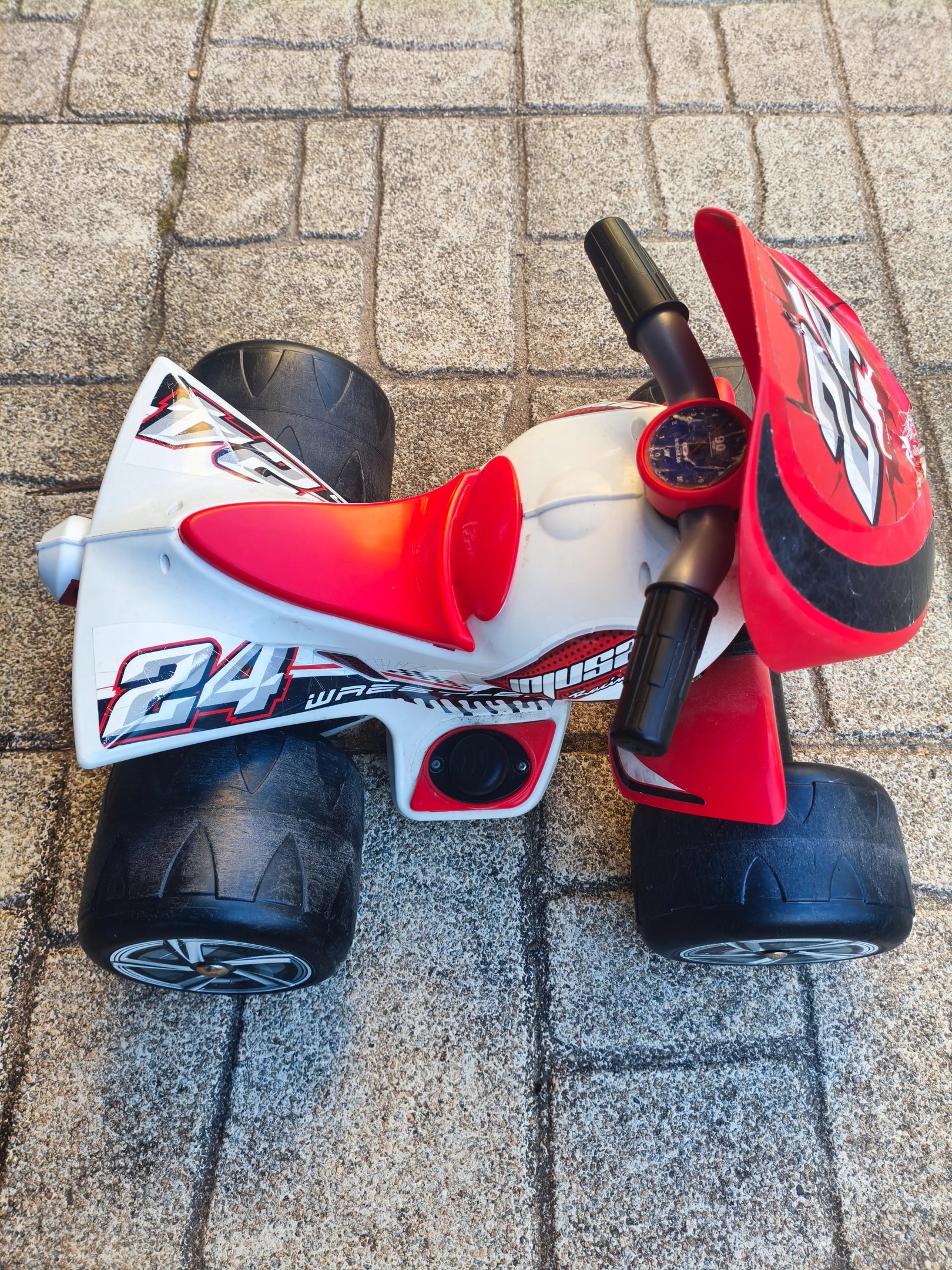 Moto 4 elétrica Injusa Wrestler 6V em vermelho e branco com o número 24, vista de frente em ângulo p