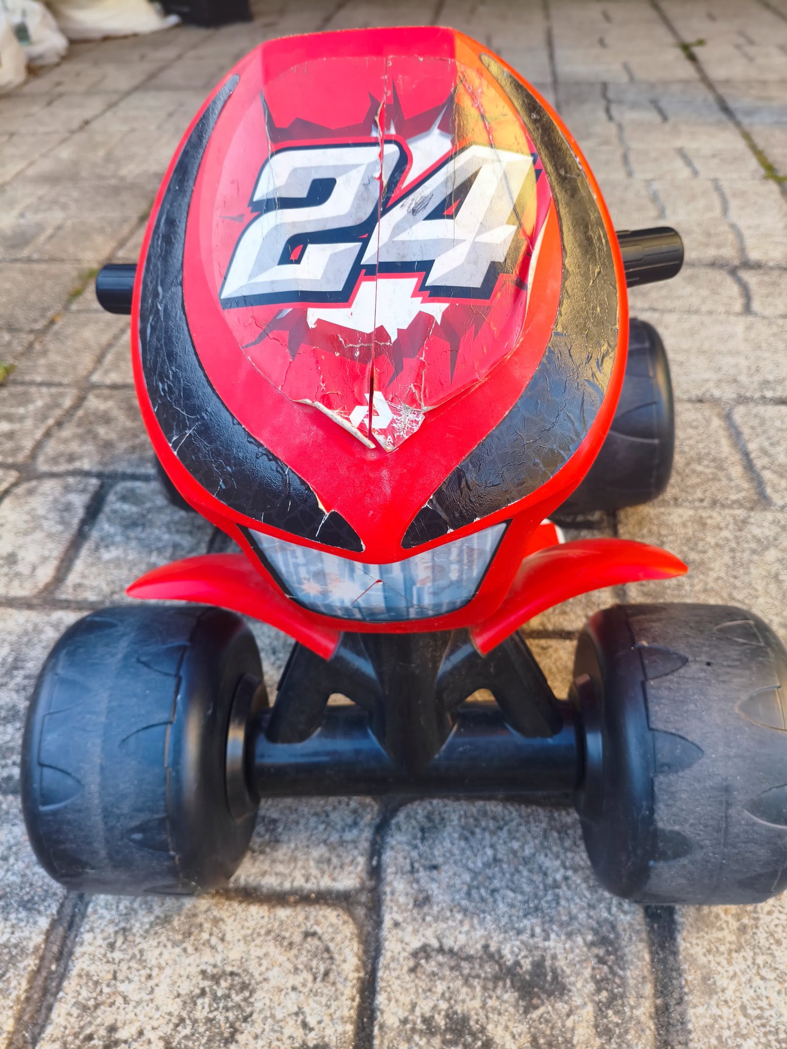 Detalhe do guiador e painel frontal da Moto 4 elétrica Injusa Wrestler 6V em vermelho e preto