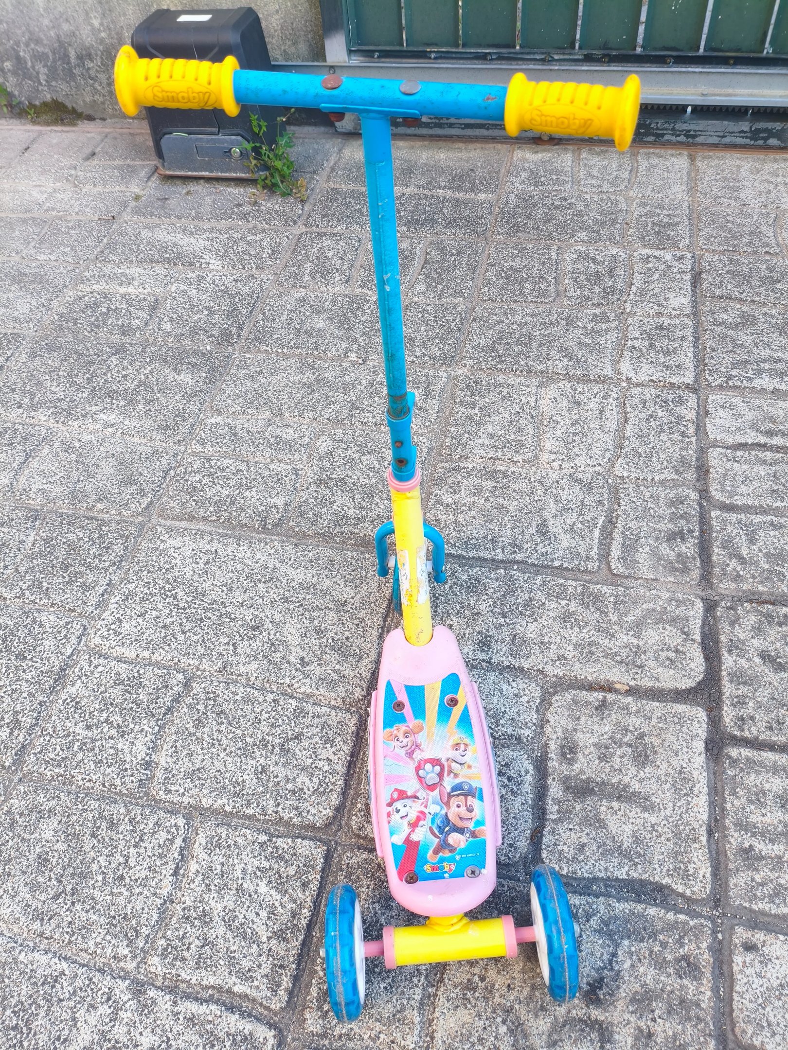 Guiador azul com punhos amarelos da trotinete Paw Patrol Smobe com sinais visíveis de ferrugem no tu