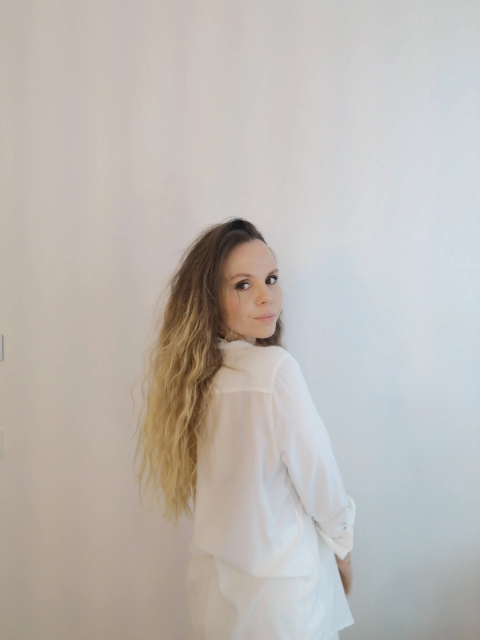 Christine Hauser, RTT Practitioner, looking back over her shoulder in a white shirt, conveying calm 