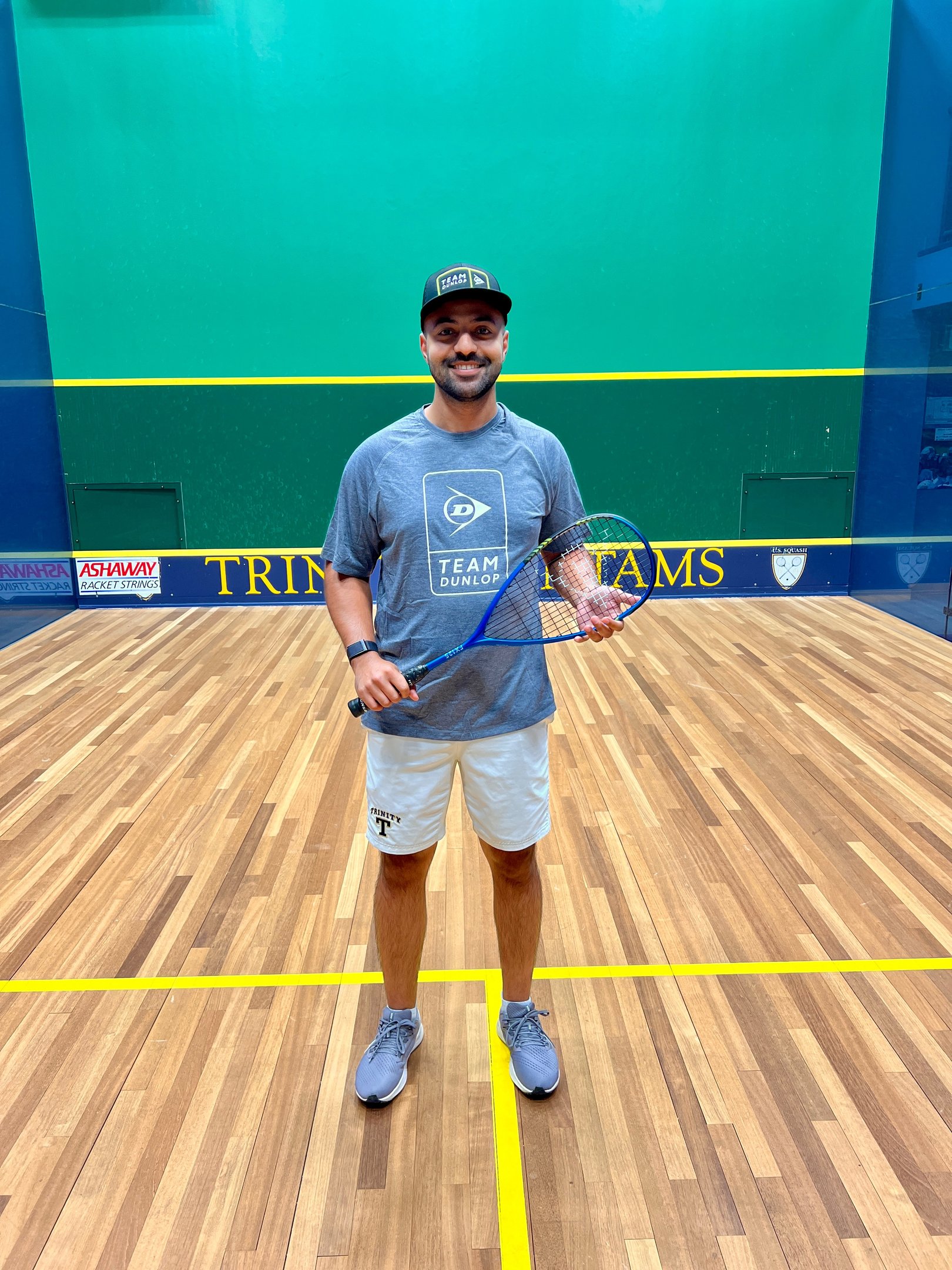 a man in a blue shirt and white shorts holding a tennis racket