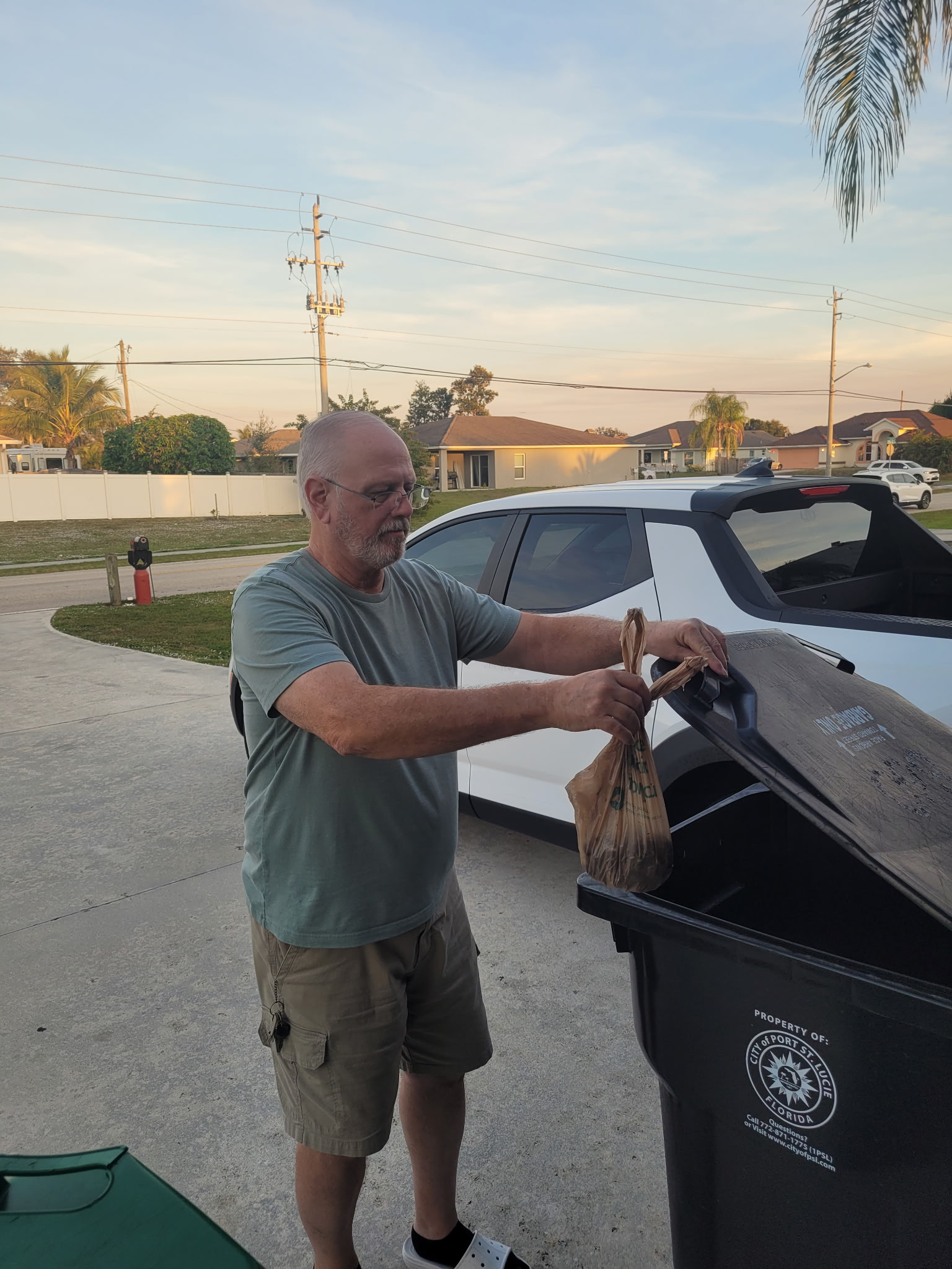 Robert placing dog waste in trash bin in psl