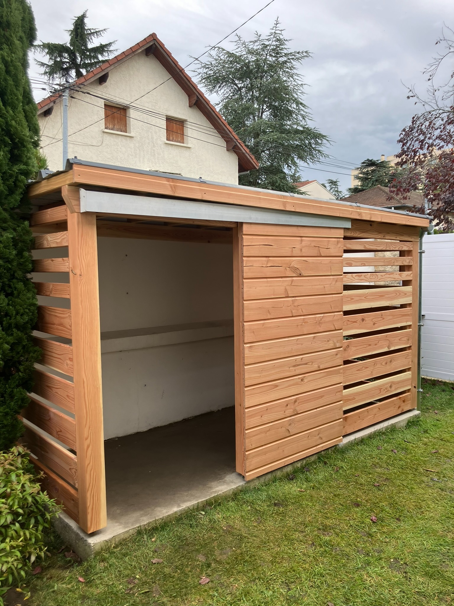 abri de jardin en bois avec porte coulissante et toiture bac acier avec gouttière zinc