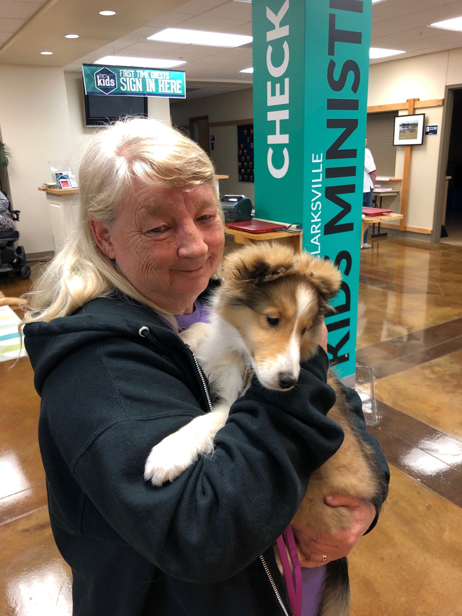 Tender Paws member Beth, holding puppy in her arms.