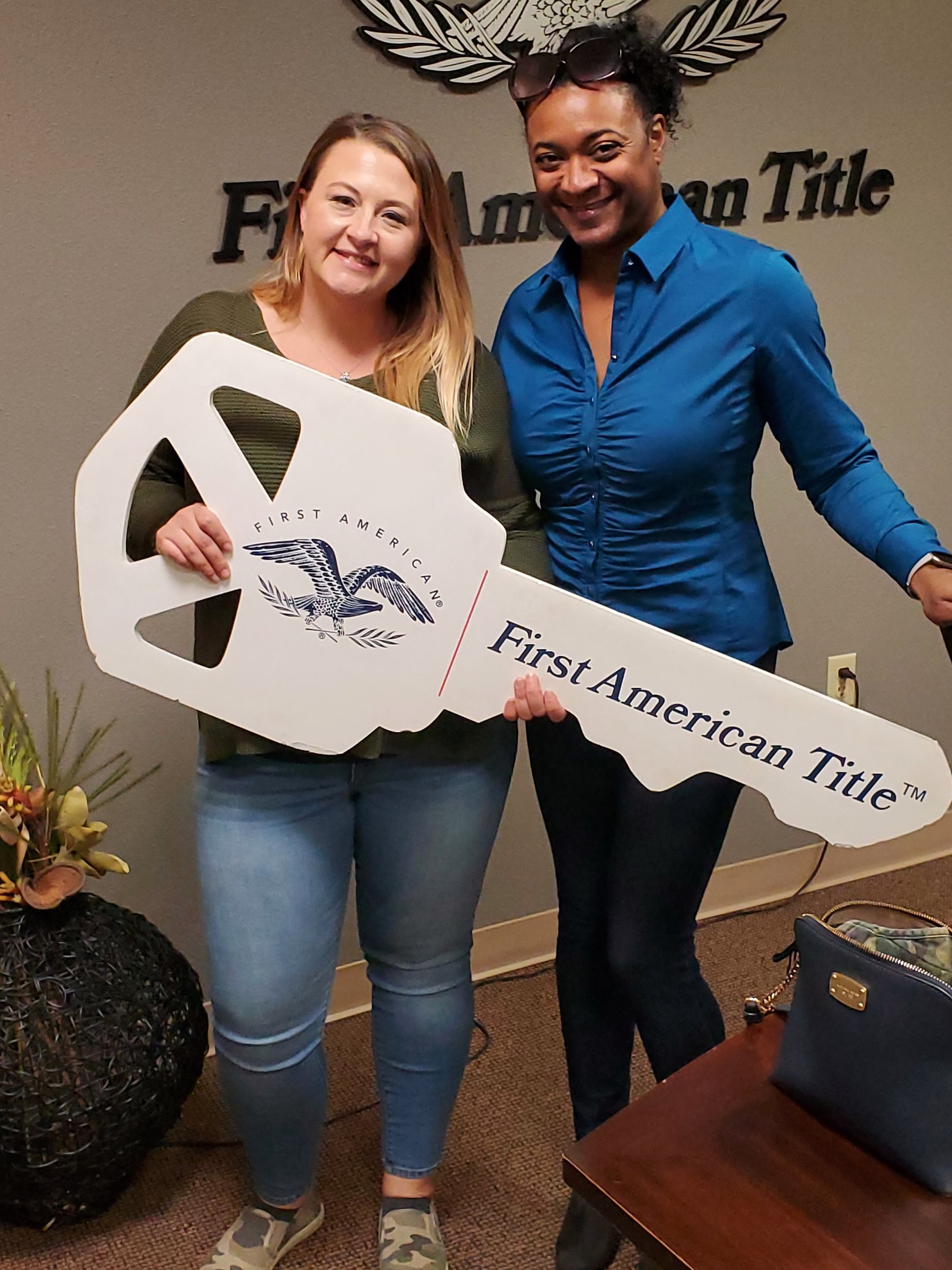 two women standing next to each other holding a sign