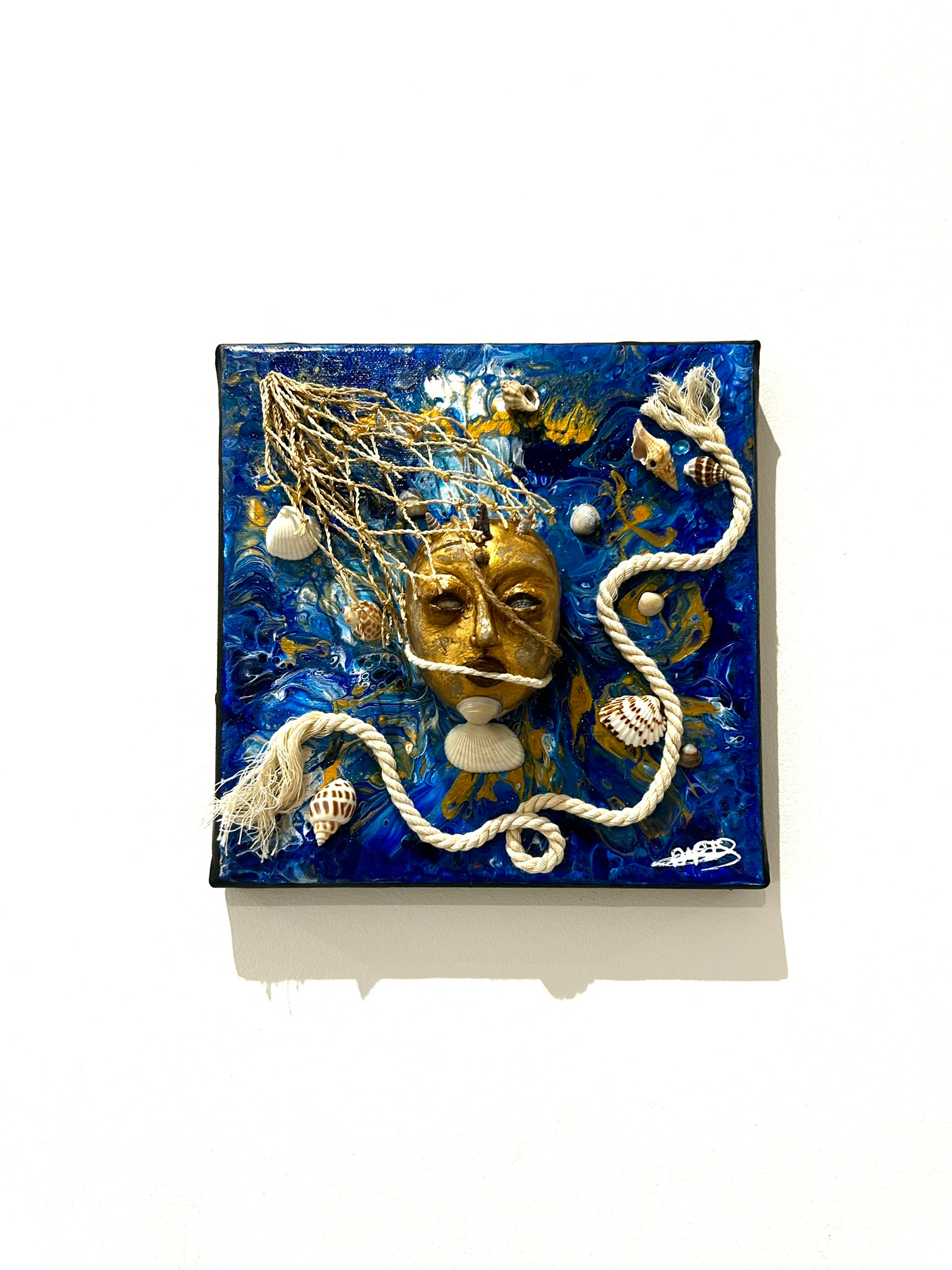 a blue and white tile with a face on it