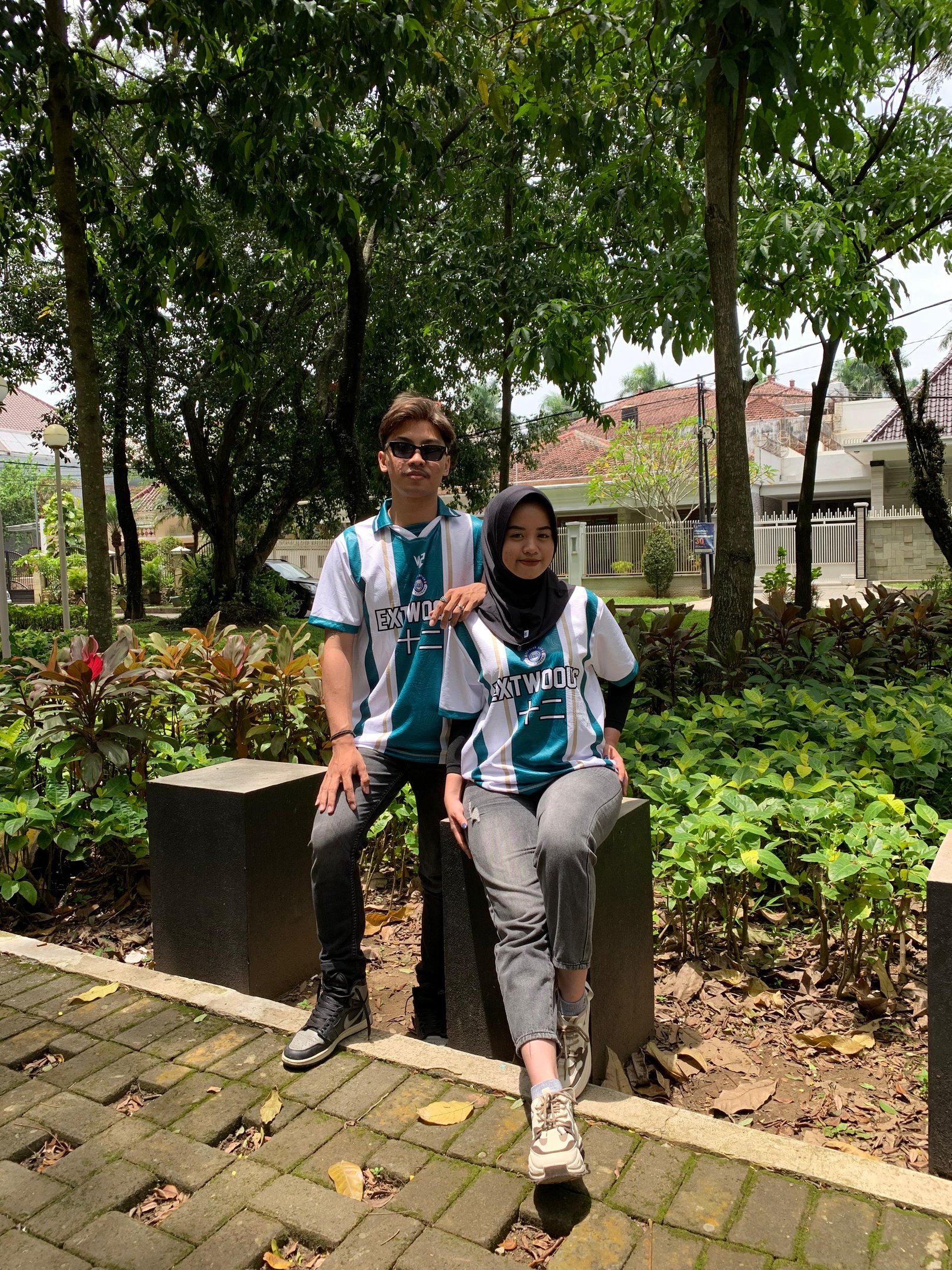 a man and woman sitting on a bench in a park