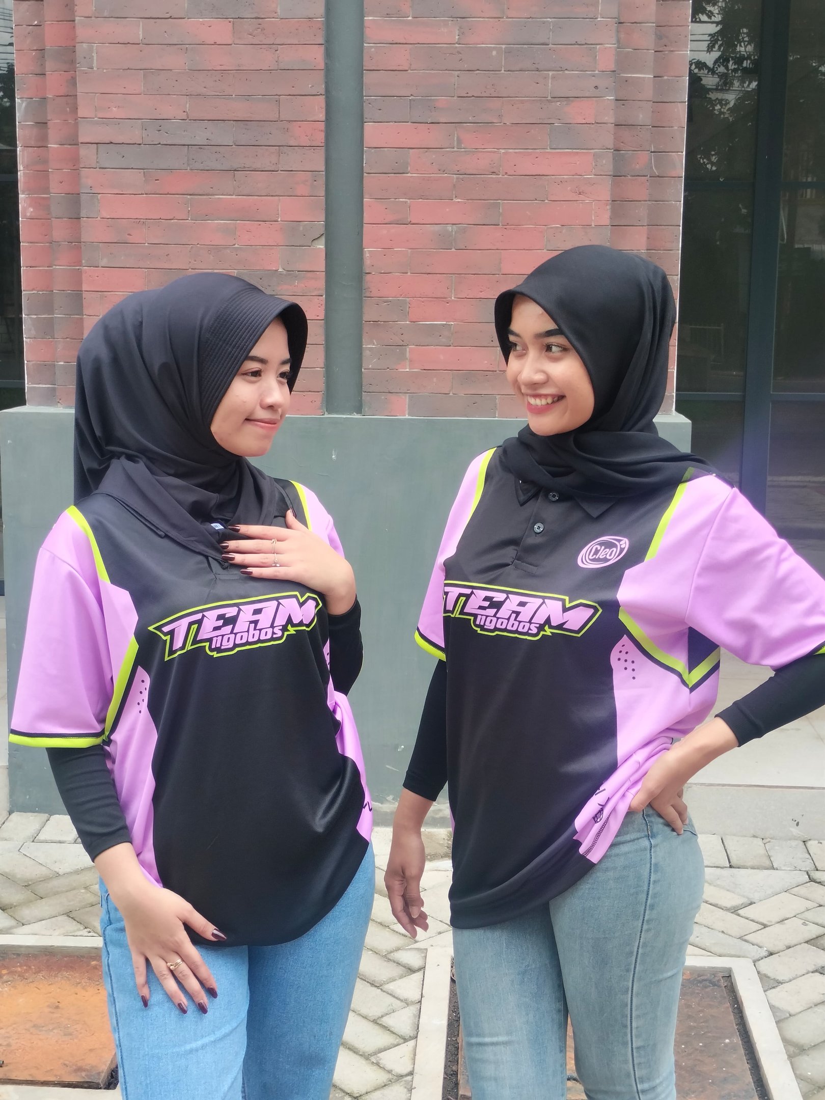 two women in hijab clothing standing next to each other