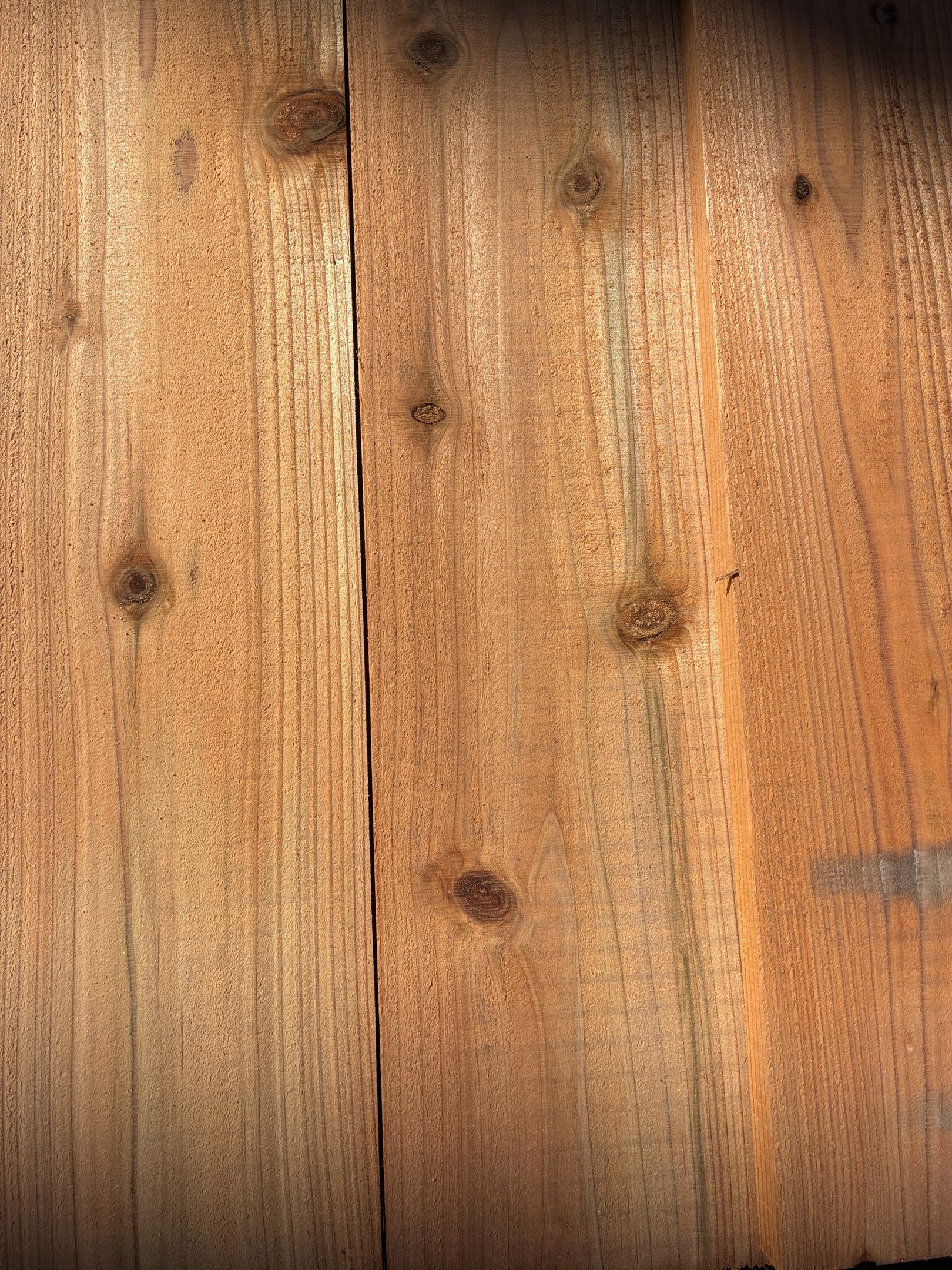 Natural sugi wood planks with visible knots and grain texture for cladding or decking.