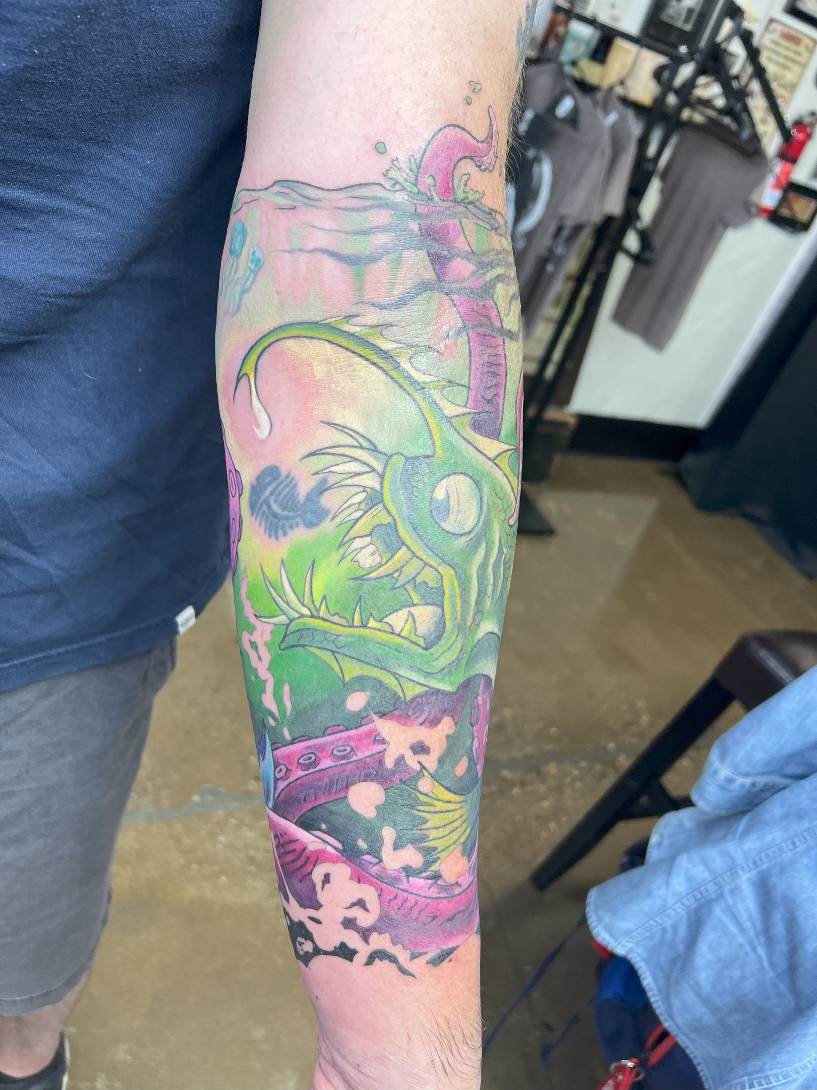 a man with a tattoo on his arm of a fish color tattoo