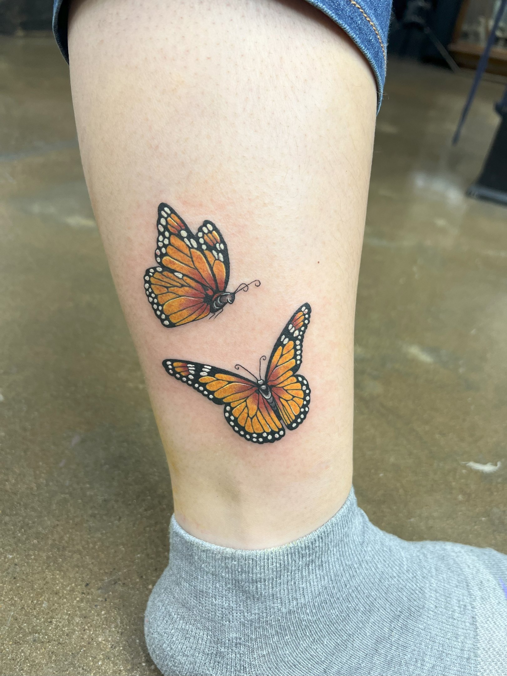 a butterfly tattoo on the leg of a woman's leg