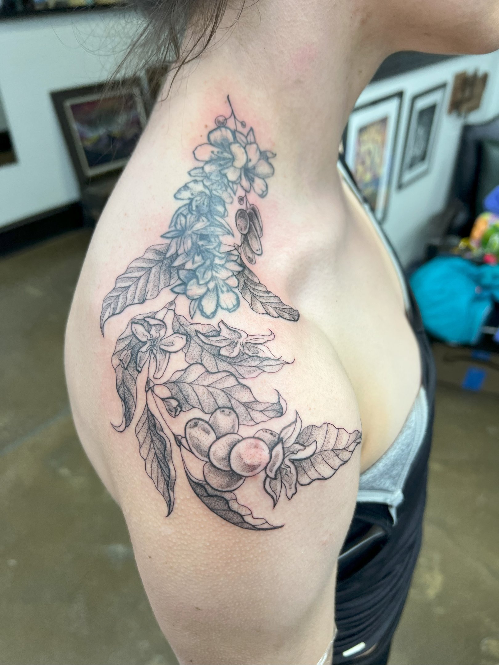 a woman with a tattoo on her chest and shoulder delicate leaf design