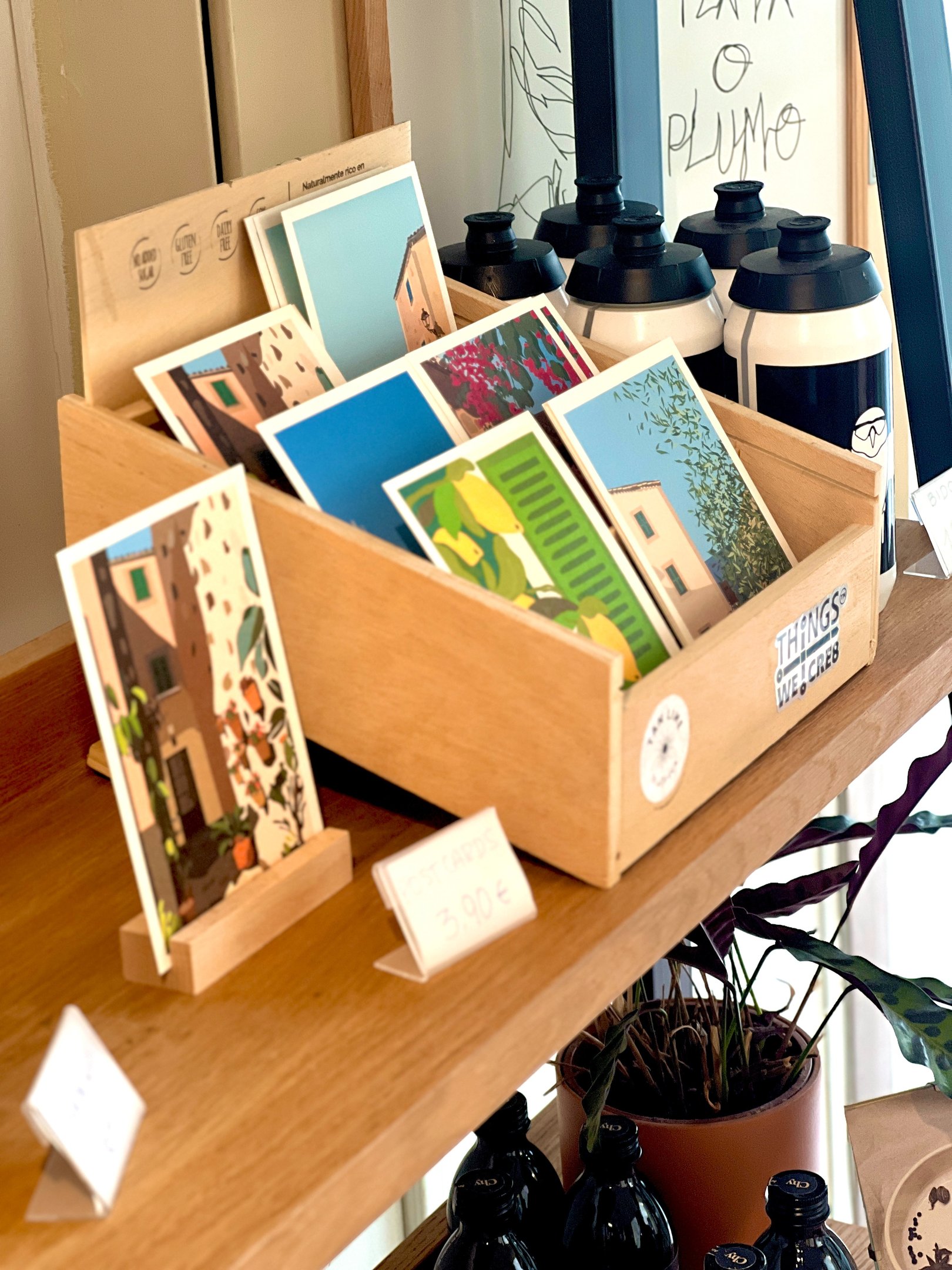 a display of postcards on a shelf designed by Carina Exner