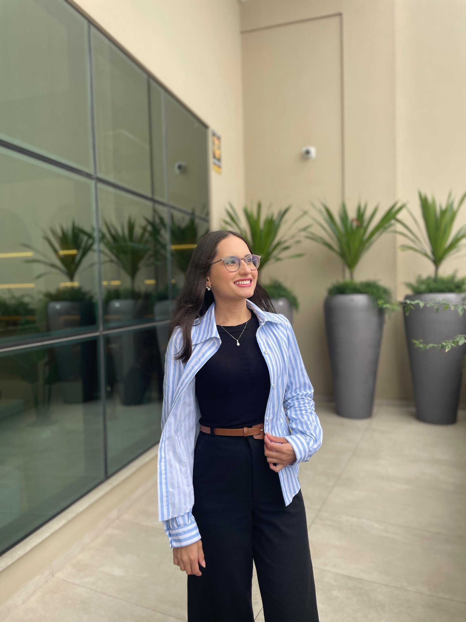 Mulher em pé usando uma camisa slim listrada