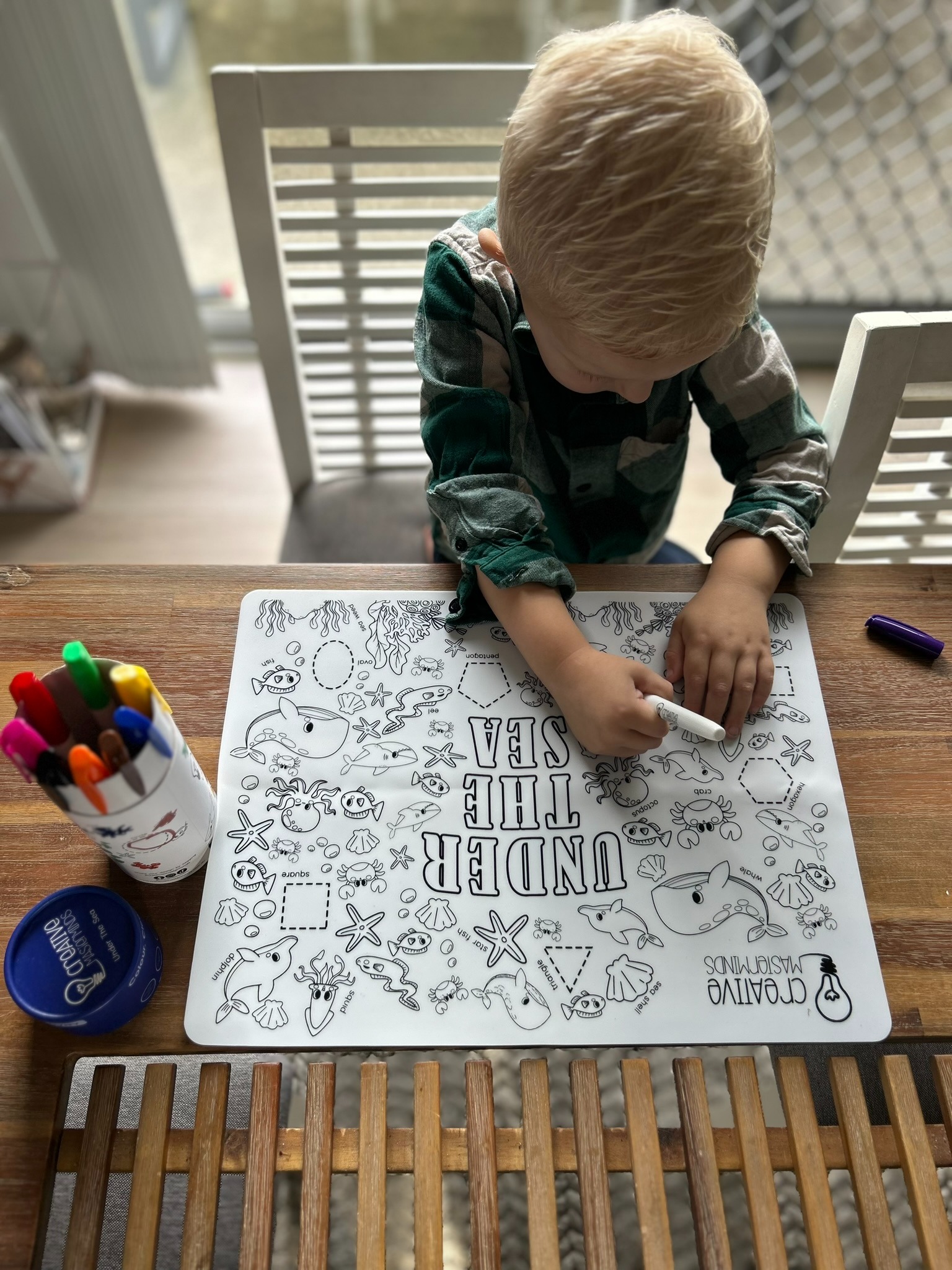 Toddler tracing sea animals on Scribbly Kids Under the Sea reusable drawing mat