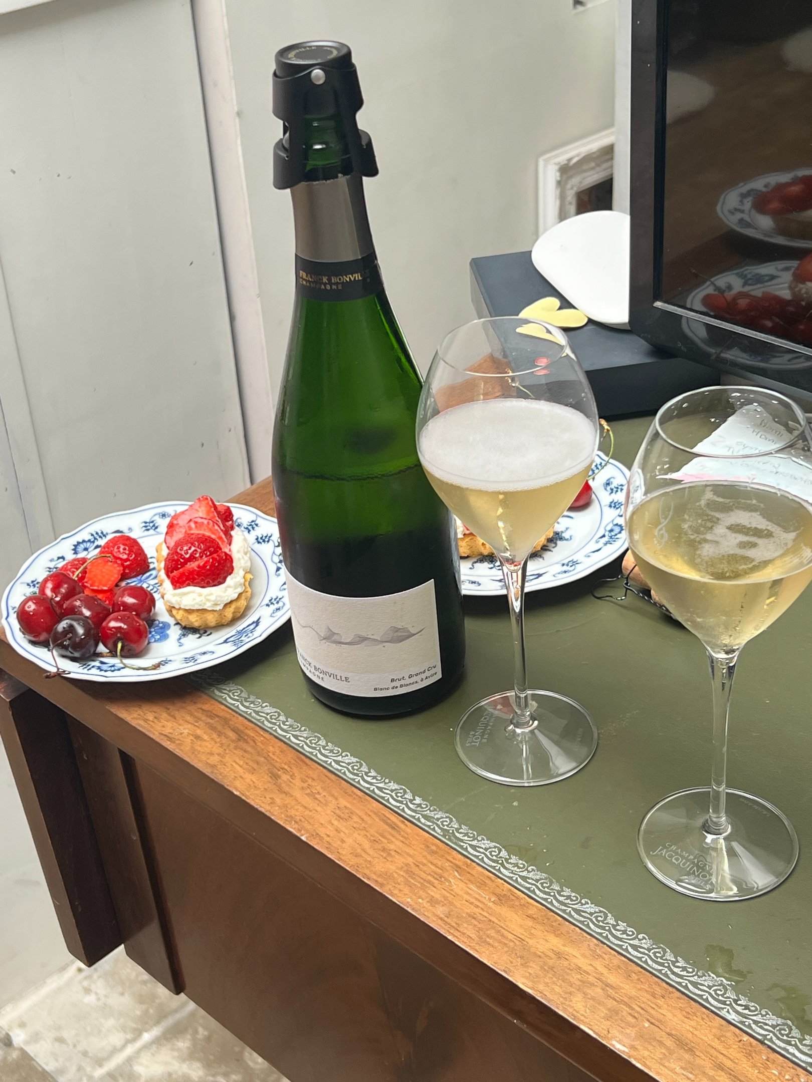 Champagne, fresh berries and strawberry pastries arranged on a table, capturing a simple moment of everyday luxury.