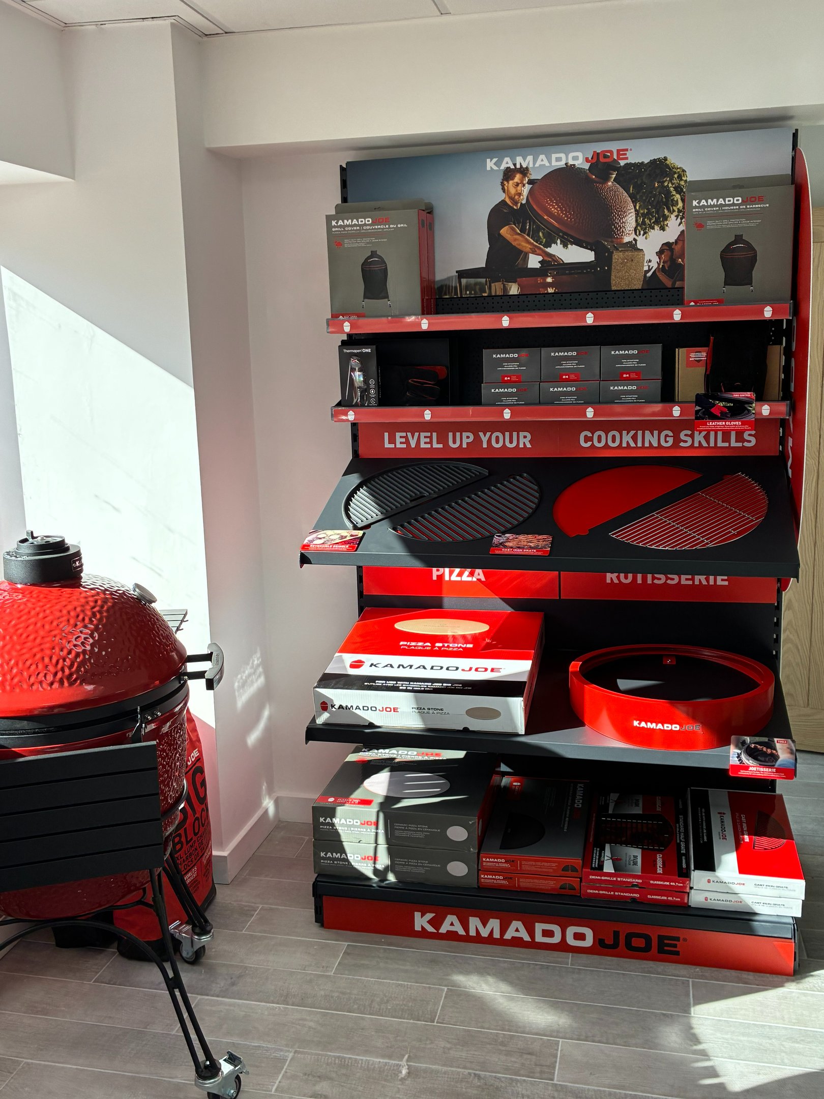 Kamado Joe accessory display at Outdoor BBQ Kitchens showroom in Southampton featuring charcoal, piz