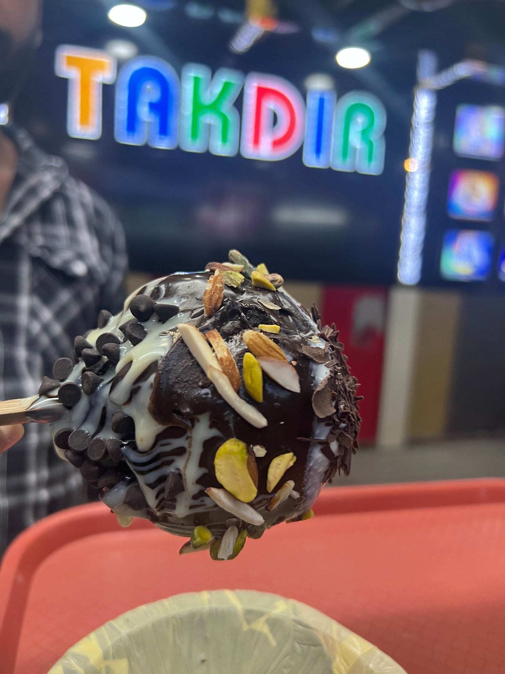 a chocolate covered dessert on a plate with a man in a plaid shirt