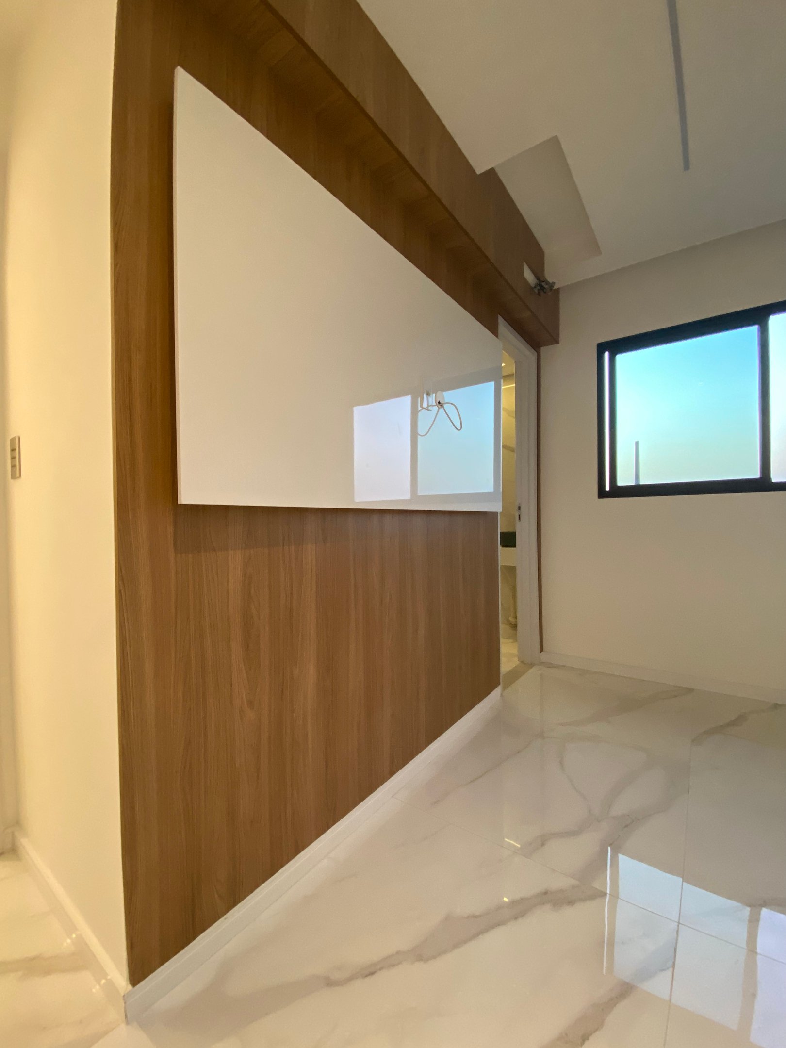 Parede com painel de madeira e acabamento branco reformada pela Nattú Engenharia, piso em porcelanat