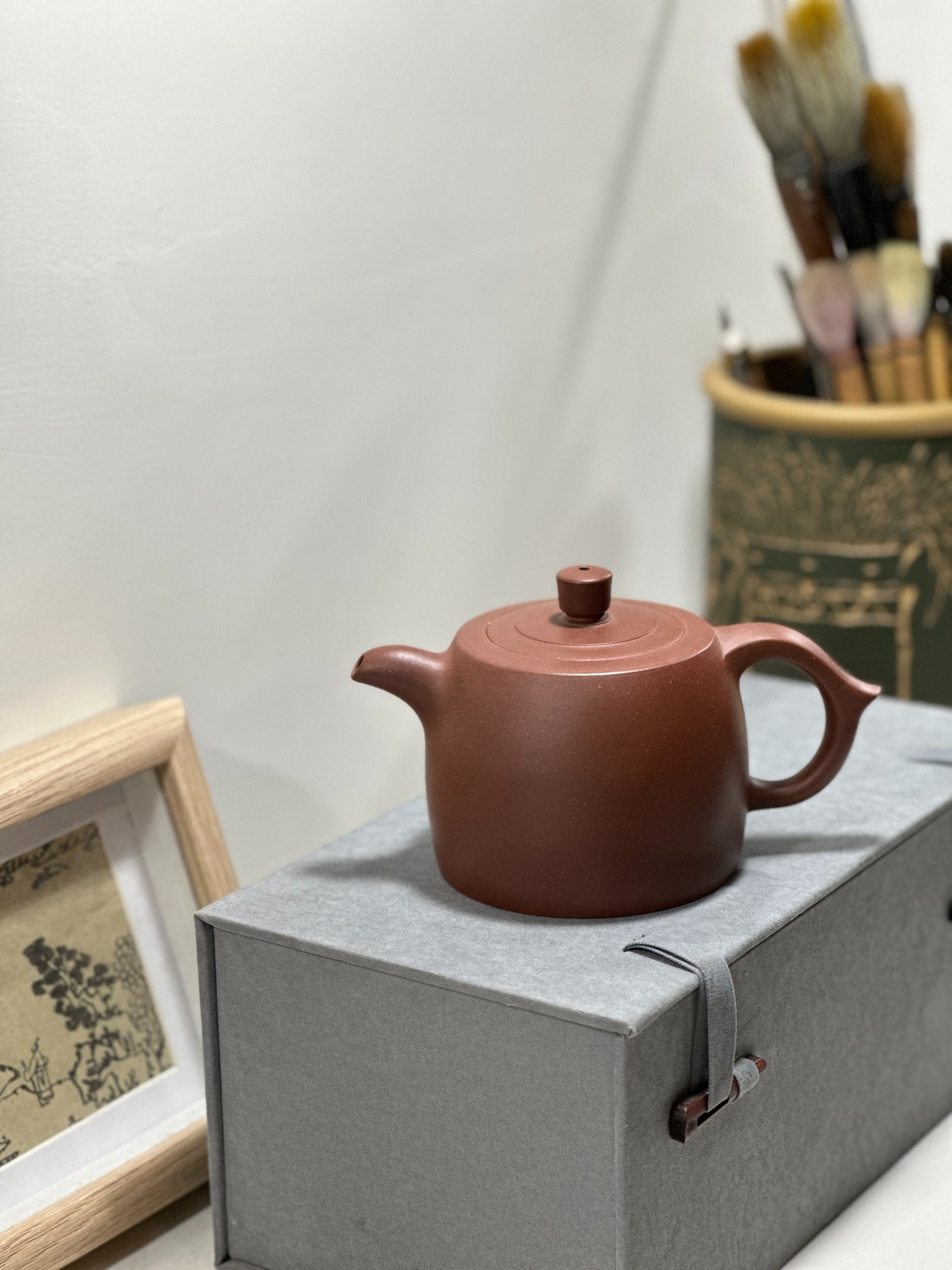 A brown Yixing teapot placed on a gray gift box