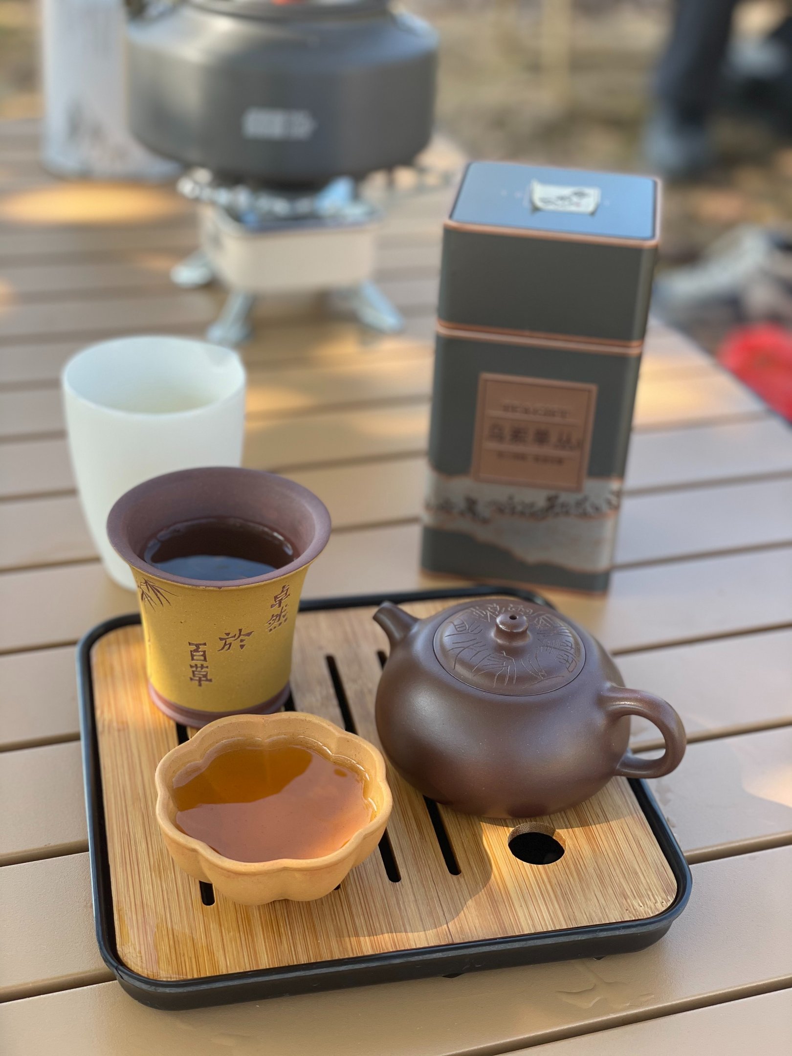teacup and teapot placed on a wooden tray