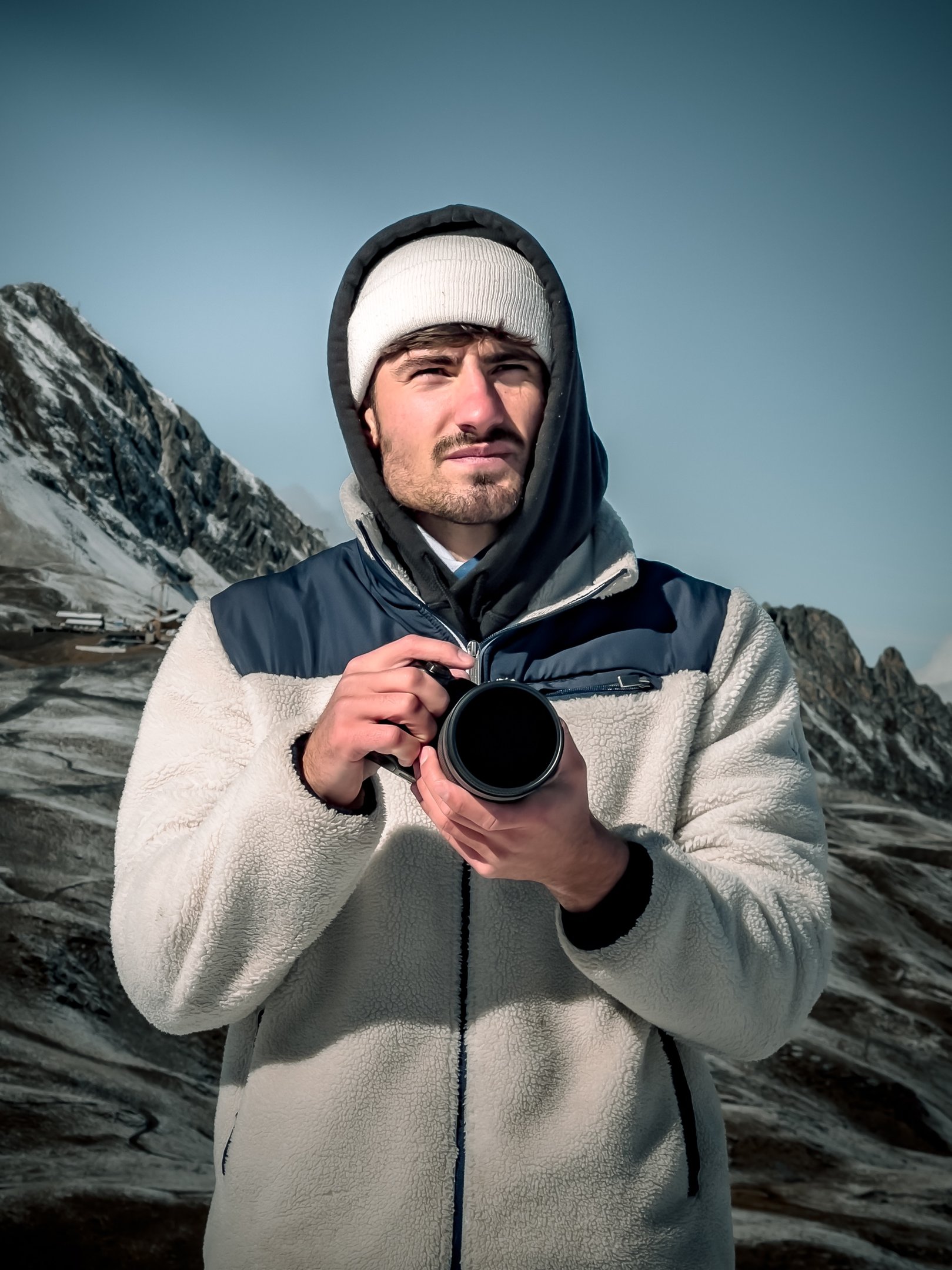 a man in a white jacket and a camera