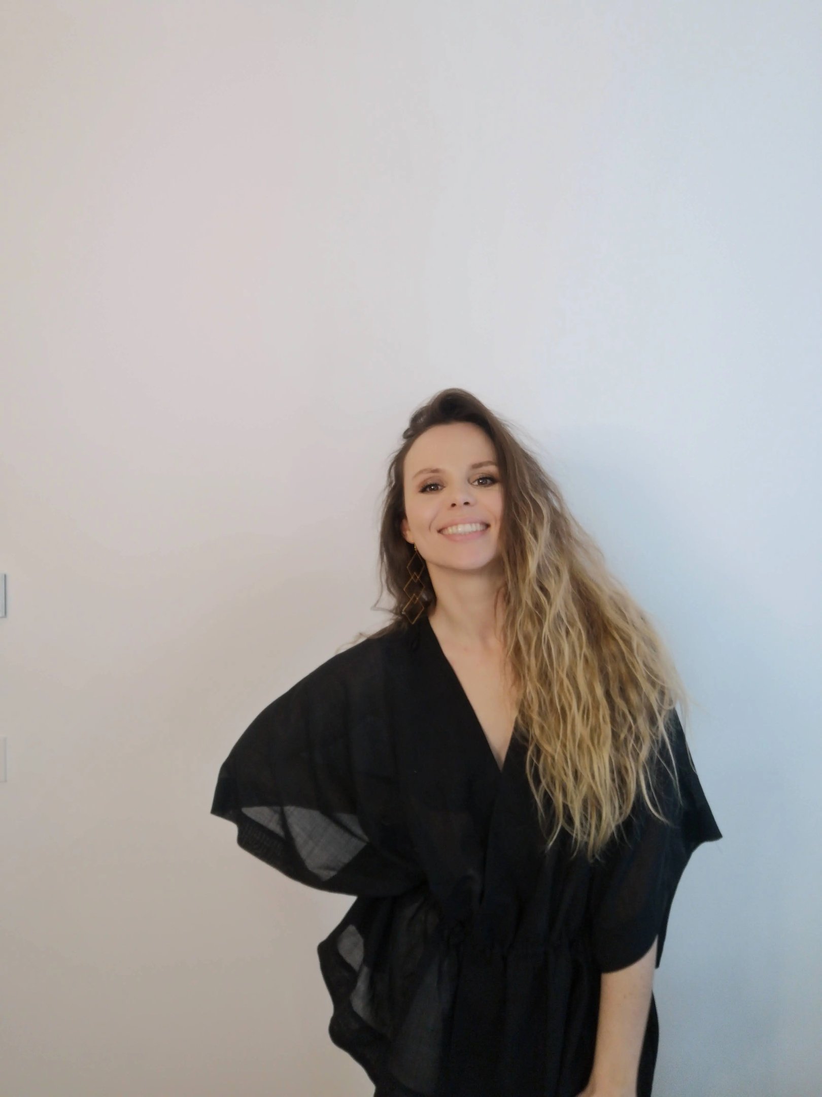 Christine Hauser, RTT Practitioner, smiling warmly in a black kimono top against a white background