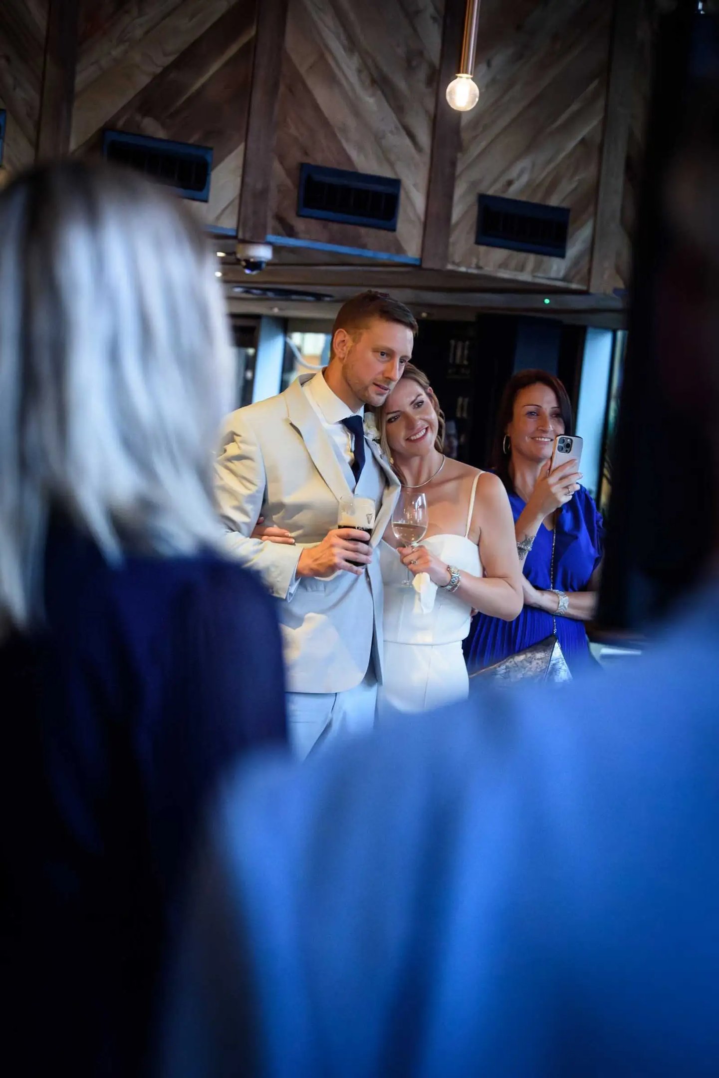 A happy bride and groom celebrate with drinks at their wedding reception venue.