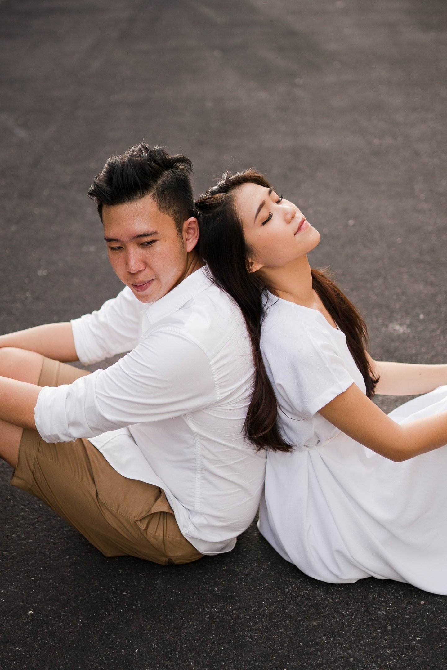 Couple sitting together in a romantic moment during proposal photoshoot at Melasti Beach Bali
