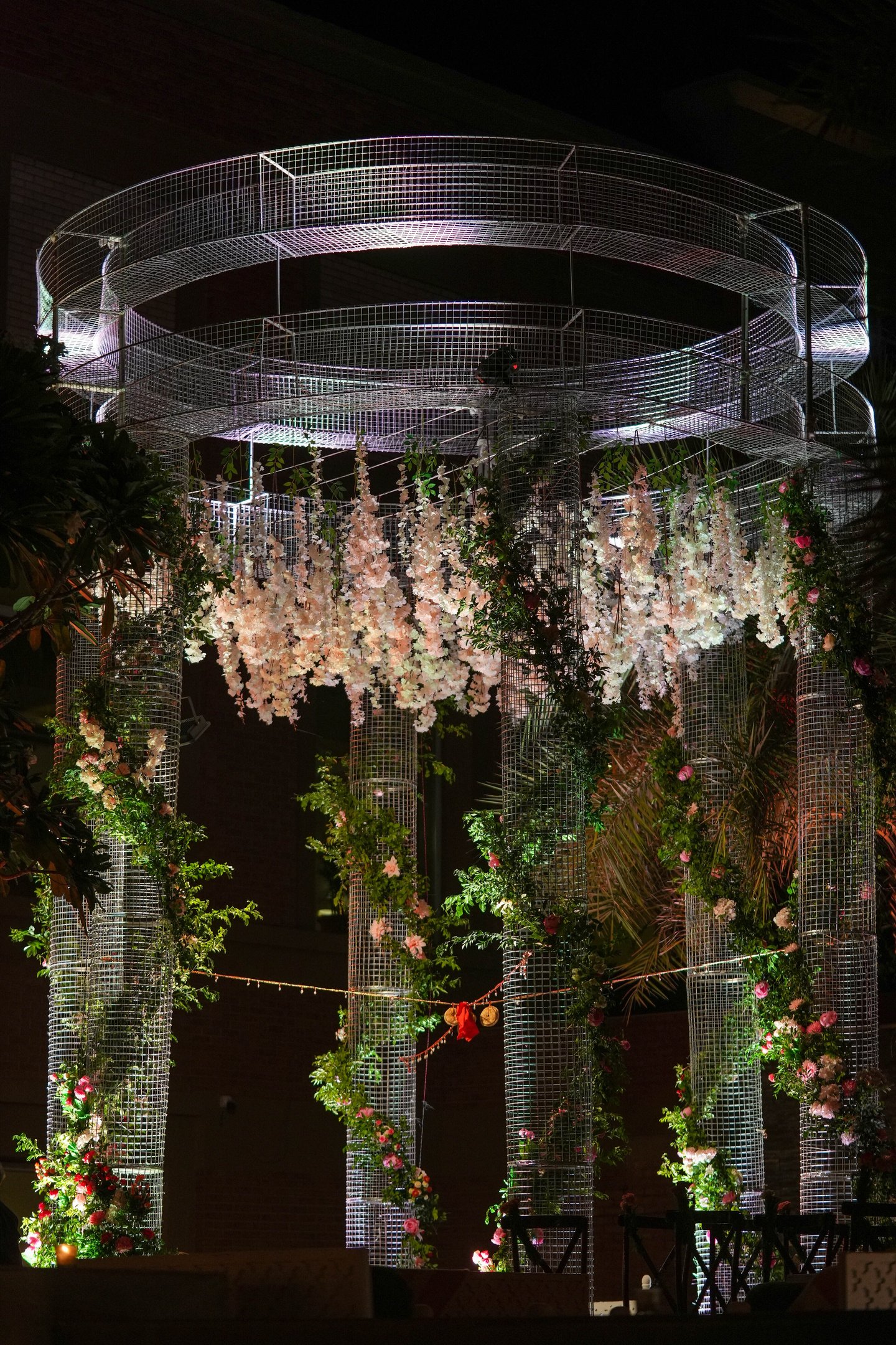 a wedding ceremony with a circular structure with flowers