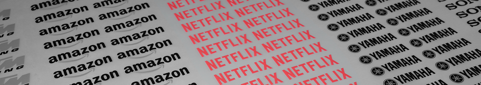 DTF textil mostrando logos impresos de Amazon, Netflix, Yamaha