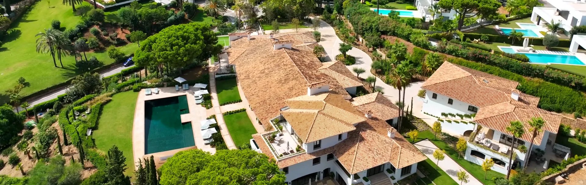 Aerial view of grand estate with pool, guest house and landscaped grounds