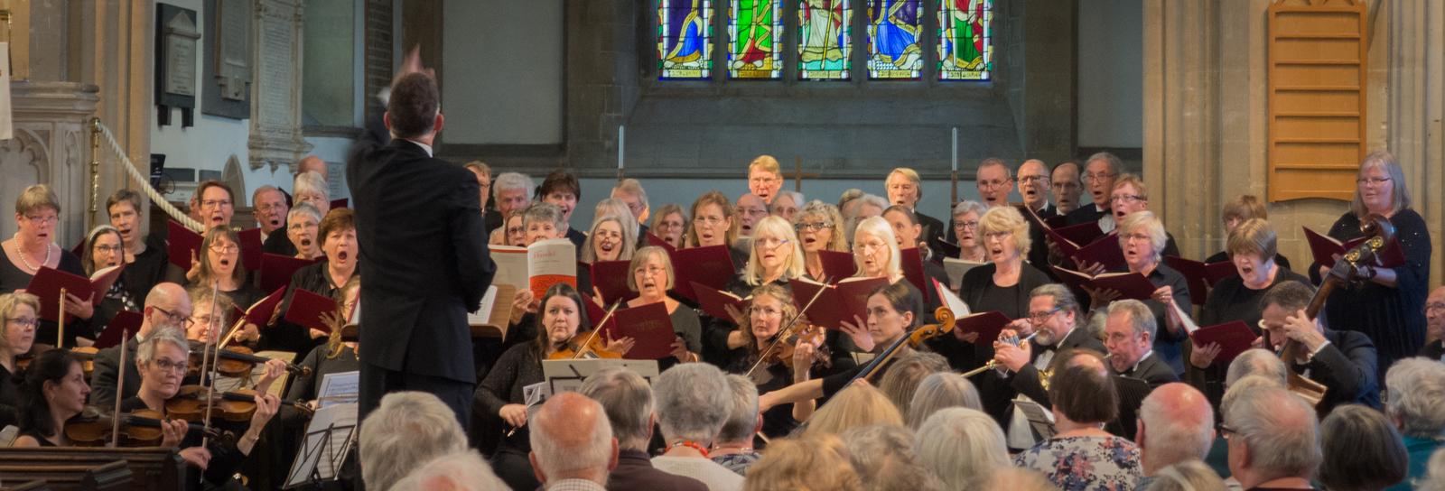 Photo of Steven Kings conducting a choir and orchestra