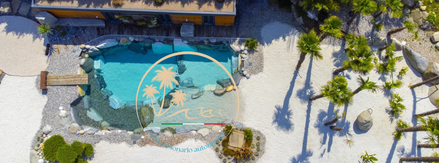 piscina scenografica con rocce sabbia e palme