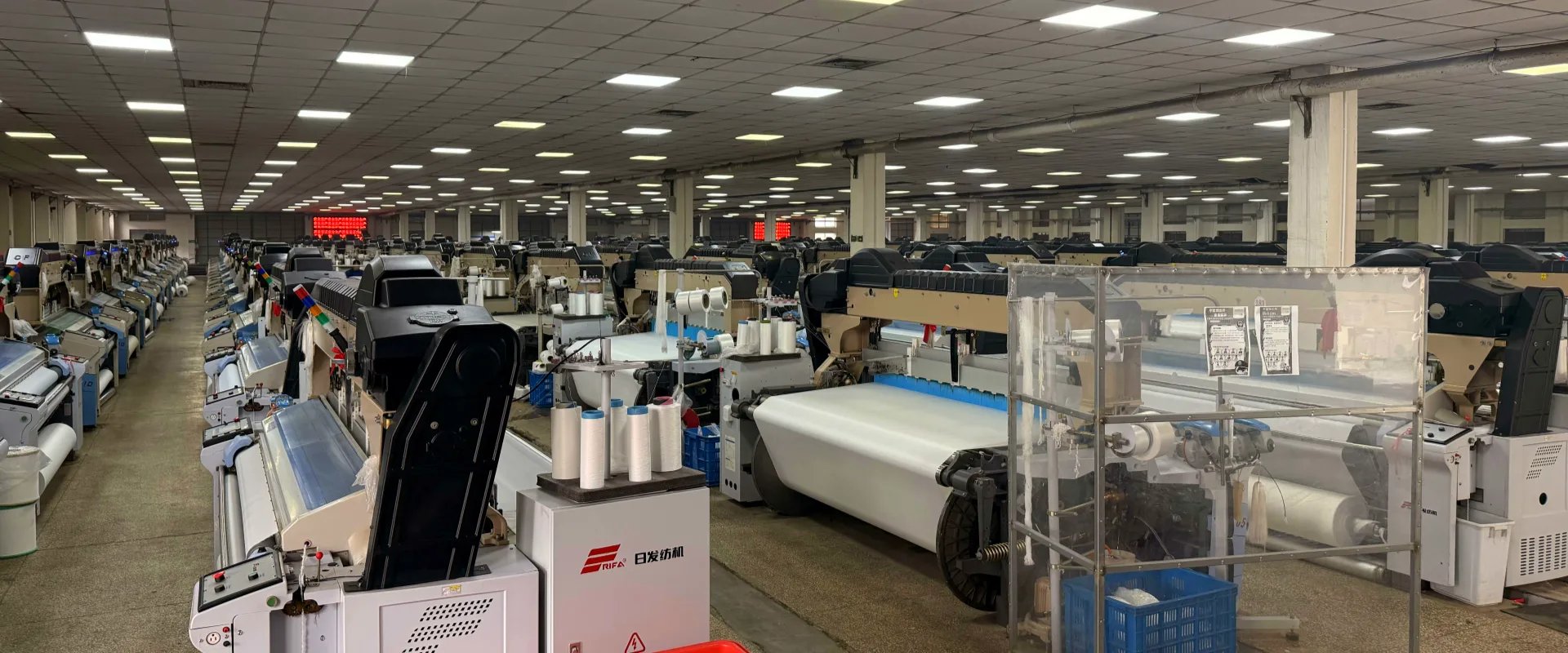 textile factory producing woven fabrics with industrial weaving equipment