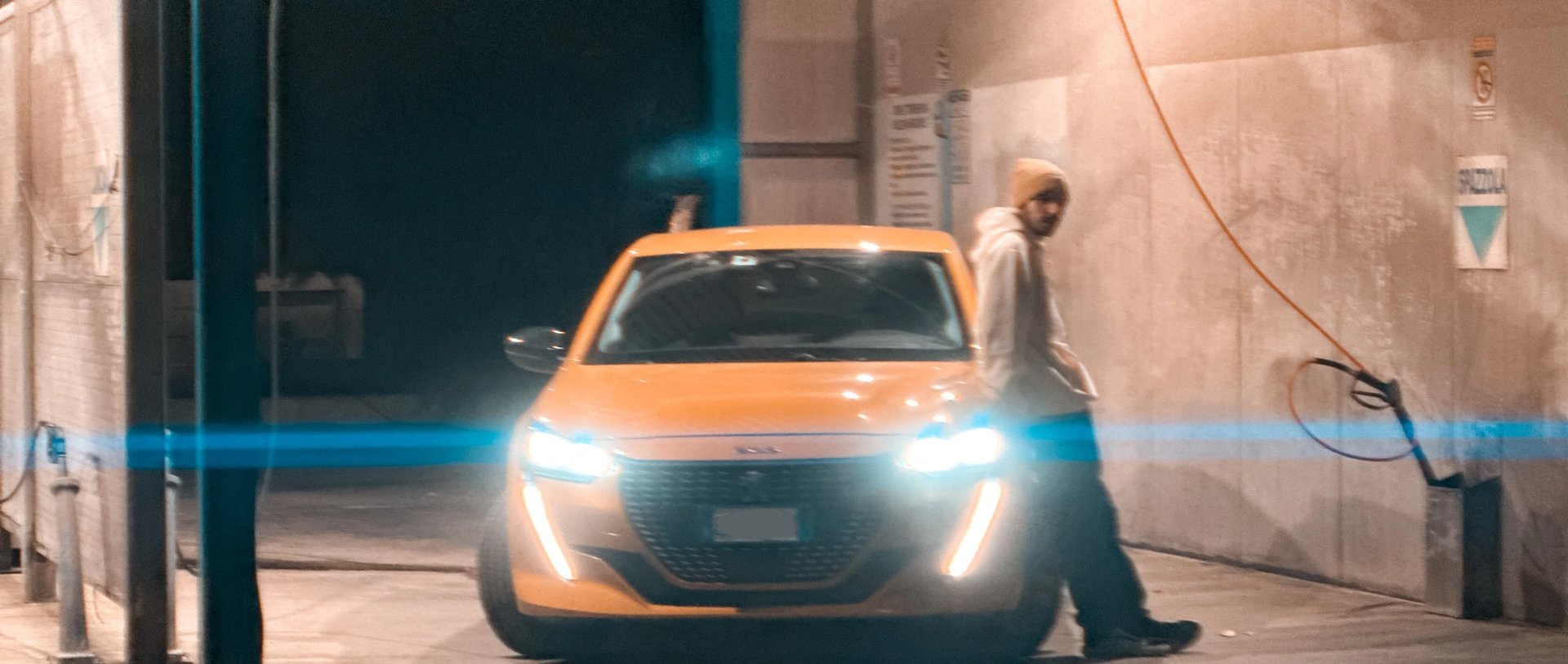 a man standing in front of a car with a light on it