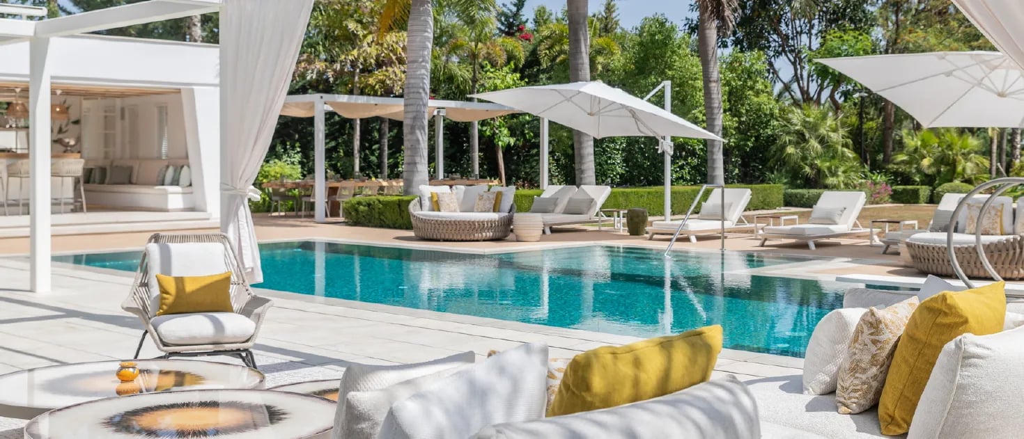 Villa Serenity poolside with daybeds and chic white pergola