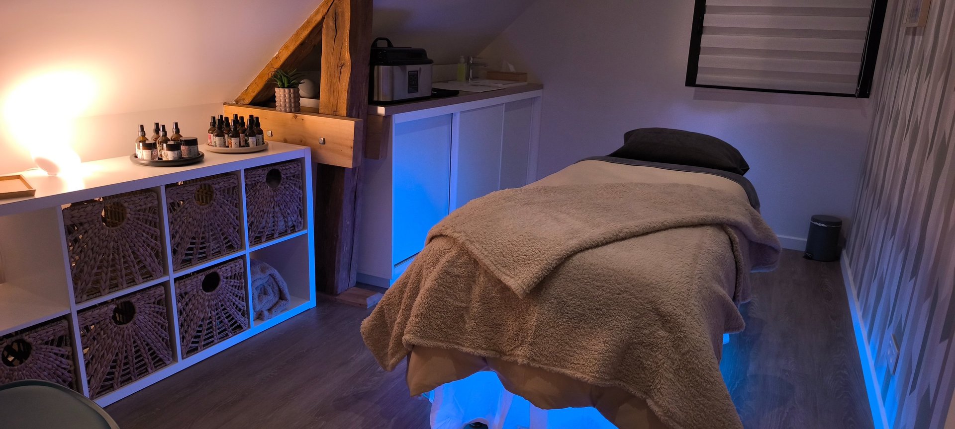 Une cabine de soin pour le massage, avec une table de massage et des huiles de massage