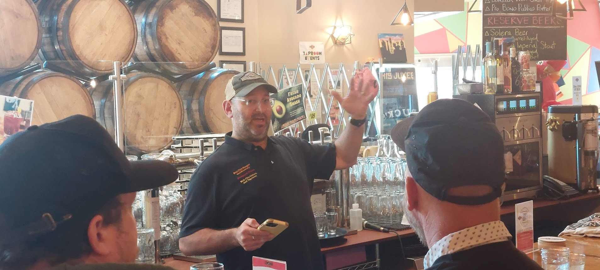 Seth Gross talking in front of an arrangement of barrels and glassware