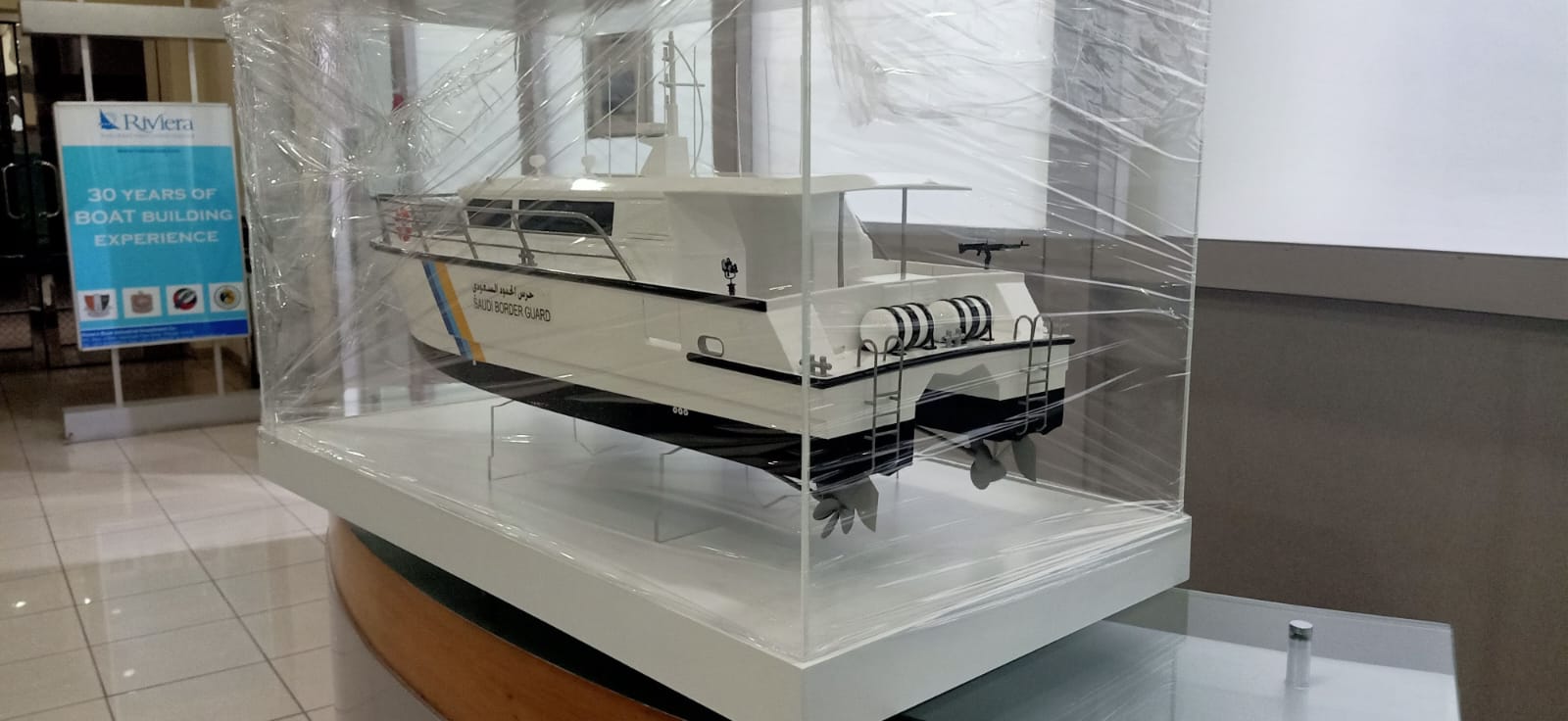 Scale model of a Saudi Border Guard patrol boat displayed in a protective glass case by Riviera.