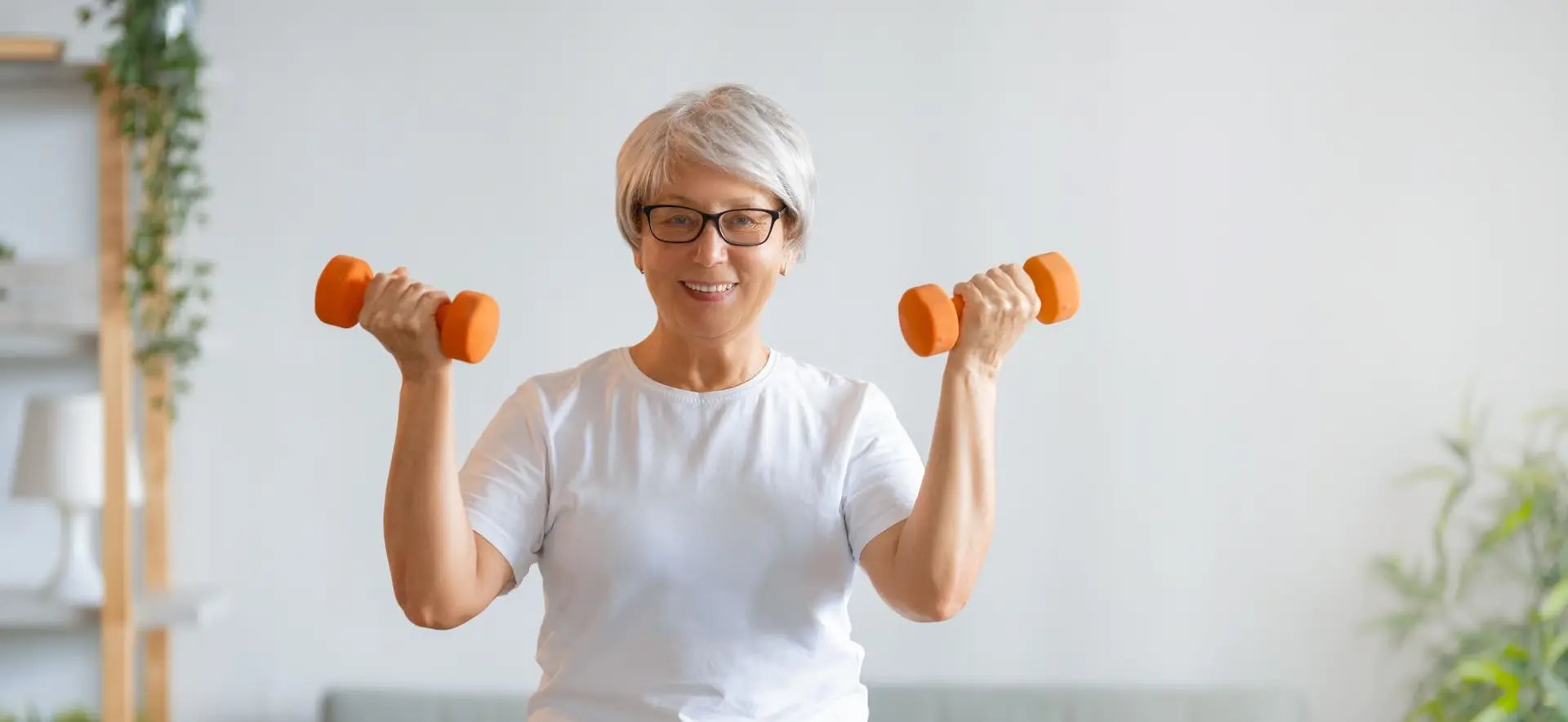 Personal trainer guiando idosa em treino funcional em casa em Braga