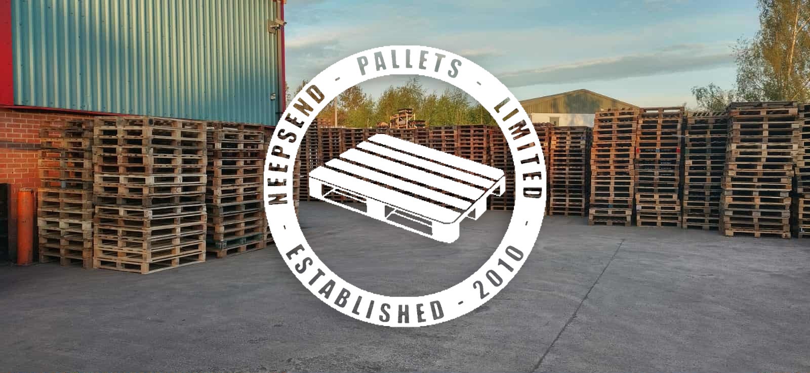 Yard with pallets and Neepsend Pallets logo