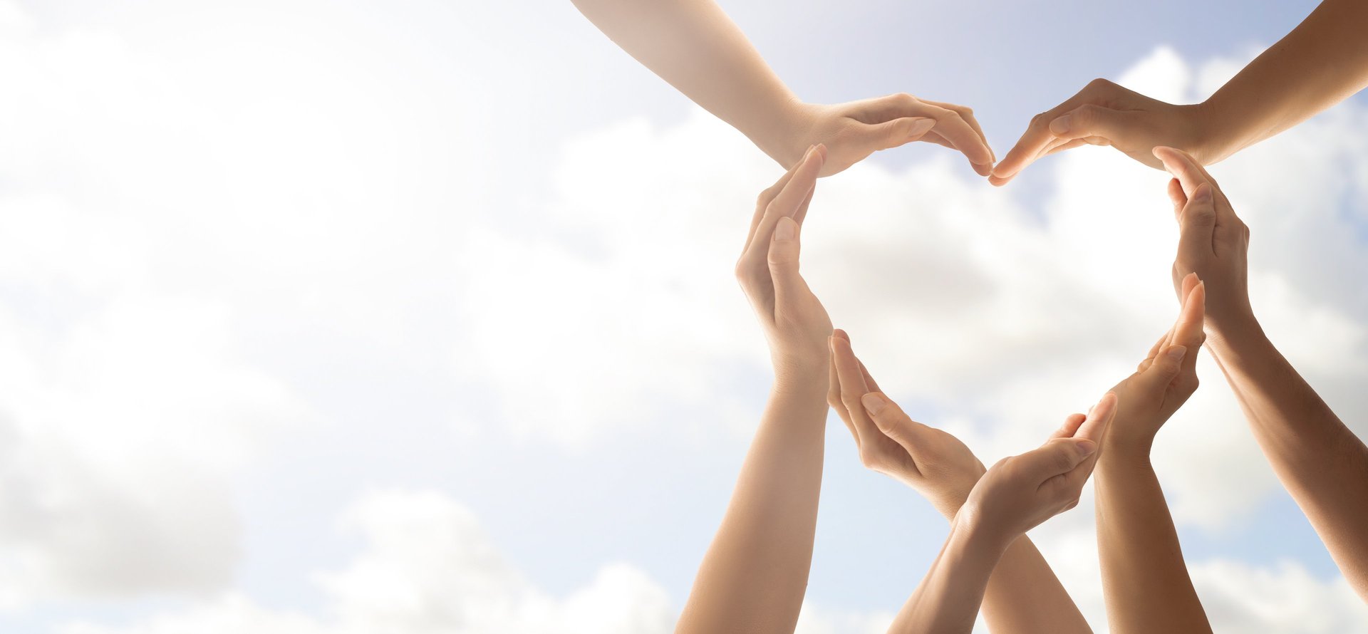 a group of people holding hands in a heart shape