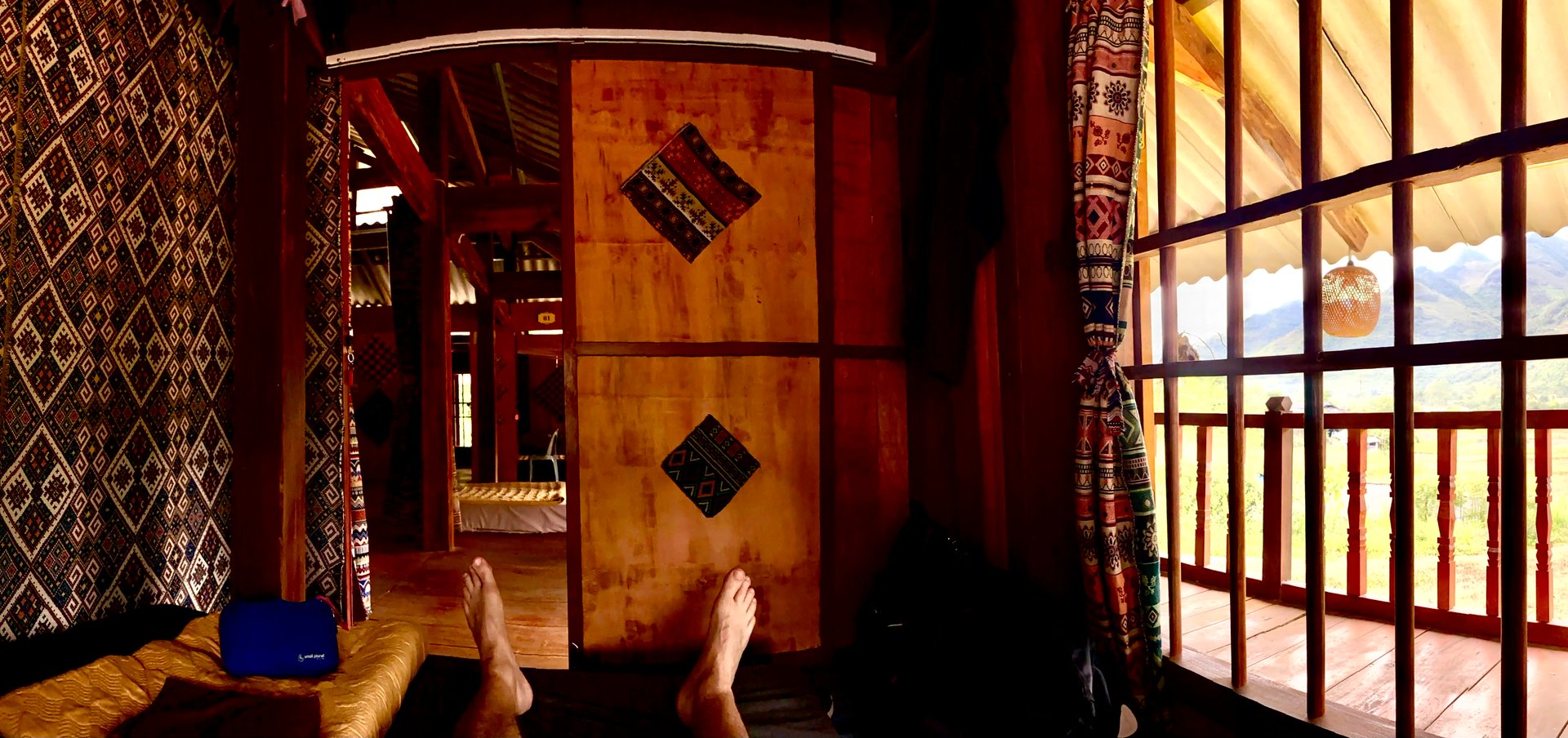 a person's feet on a bed in a homestay