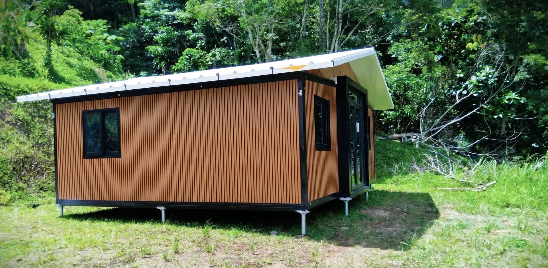 Maison conteneur préfabriquée avec bardage wpc sur vis de fondation.