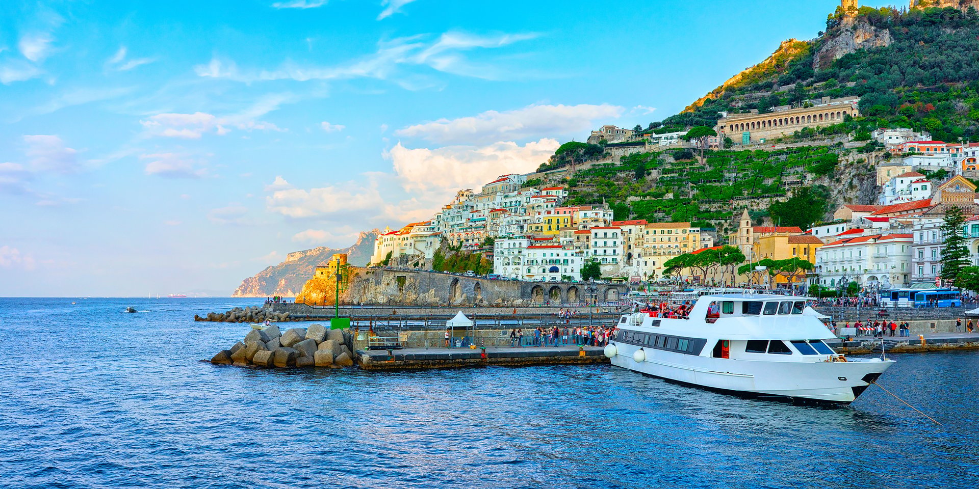 A large white ferry docked at the colorful seaside village of Amalfi on Italy's Amalfi Coast.
